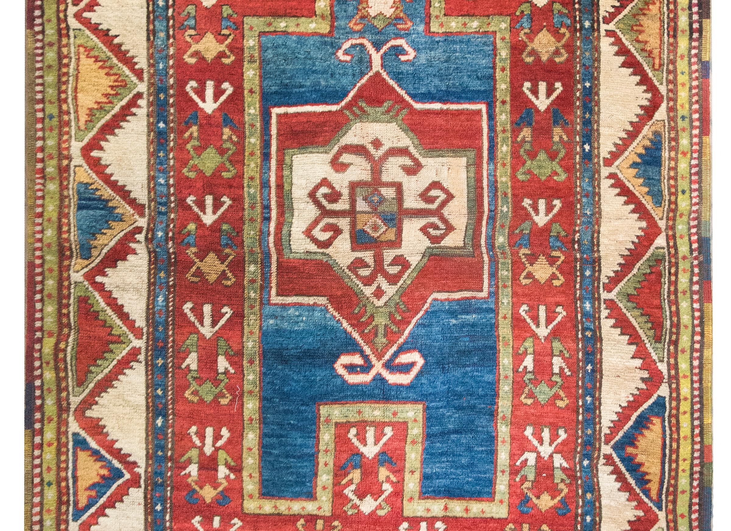 Ce tapis de prière kazak du début du 20e siècle présente un art géométrique audacieux et une riche palette de couleurs caractéristiques du tissage tribal caucasien. En son cœur, un médaillon floral stylisé s'épanouit dans un champ foisonnant de