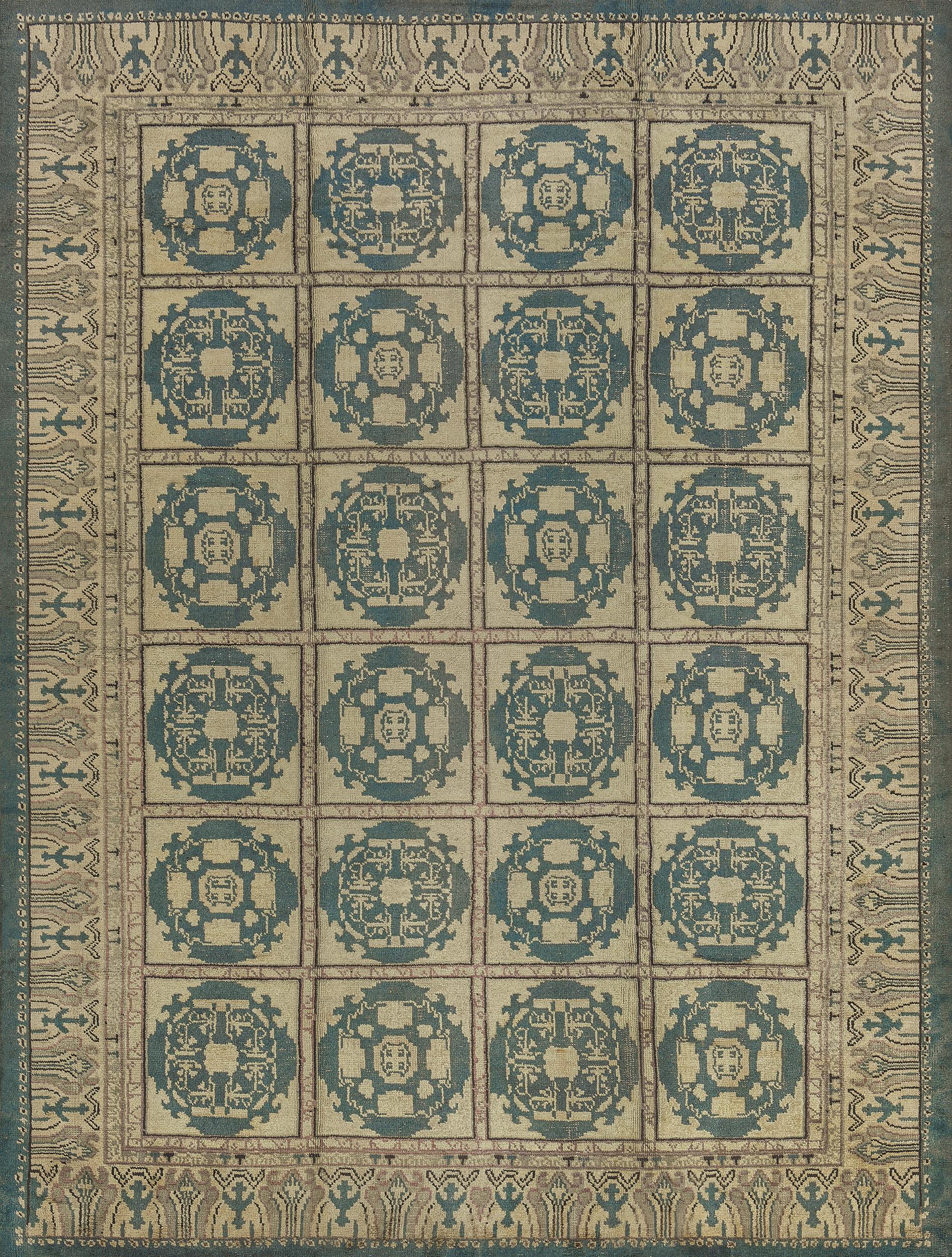 The field with four columns of six square ivory panels each containing a central shaded blue circular lozenge with a central flower head surrounded by angular vine linking stylized flower heads, in a broad ivory and light grey angular inward facing