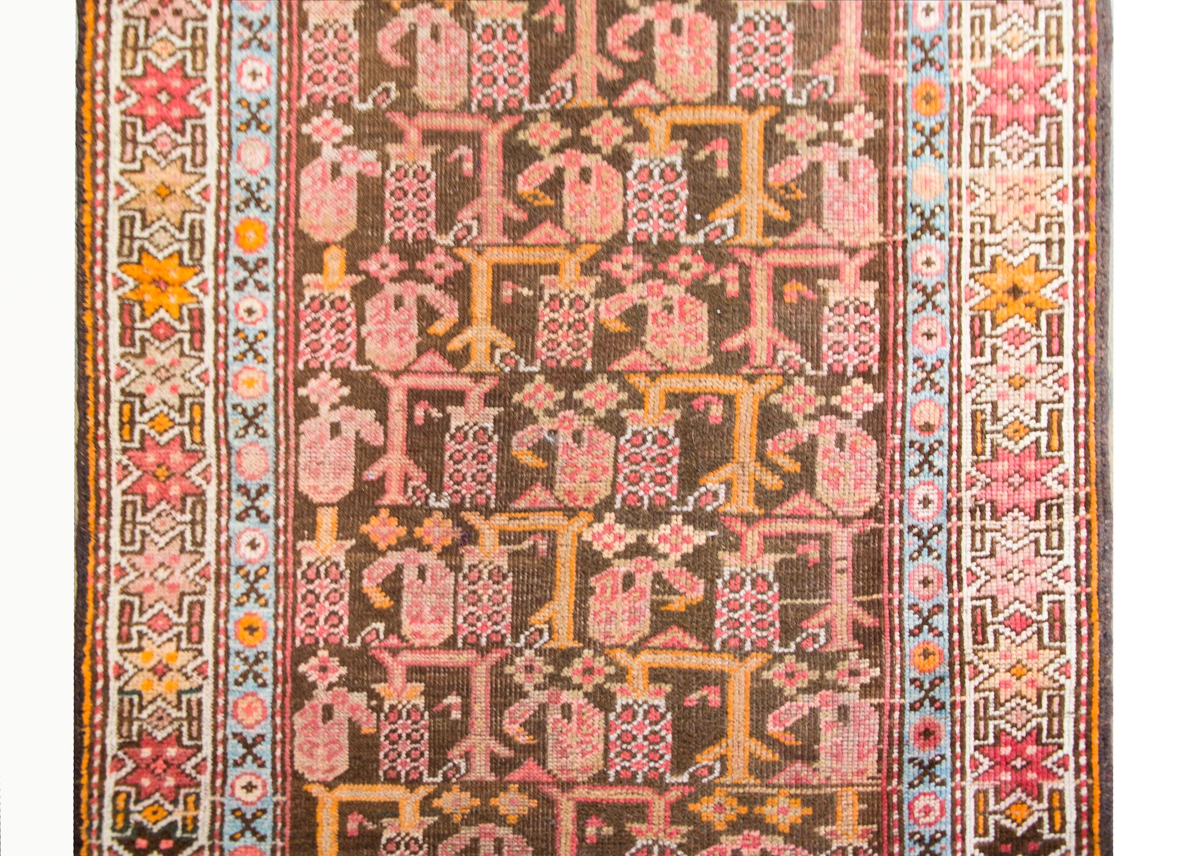 A wonderful early 20th century Persian Kurdish runner with an incredible all-over abrash stylized floral pattern containing myriad trees with flowers surrounded by even more stylized flowers and petite geometric patterned stripes, and all woven in