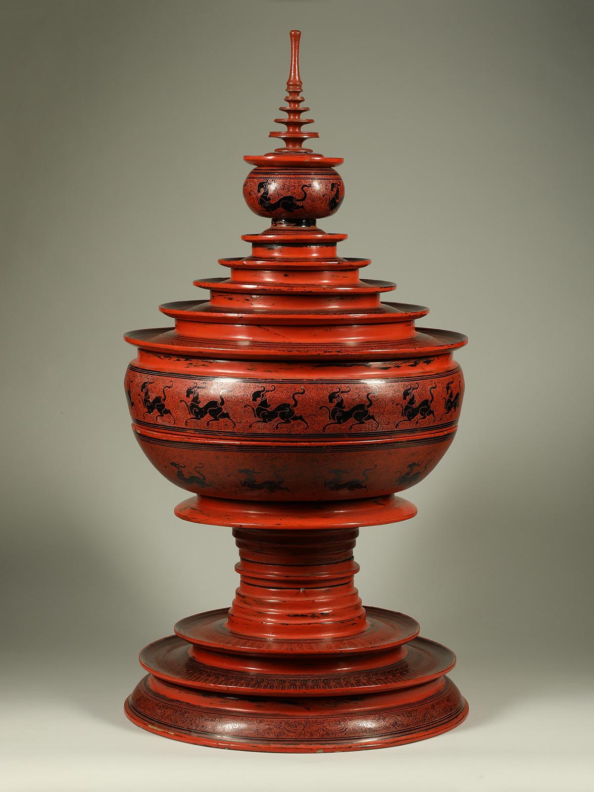 Late 19th or early 20th century lacquer and bamboo offering vessel, Hsun Ok, Pagan, Burma

A large offering vessel composed of four pieces, a base, a large food bowl with lid and the finial. Two rows of high-stepping mythological beasts embellish