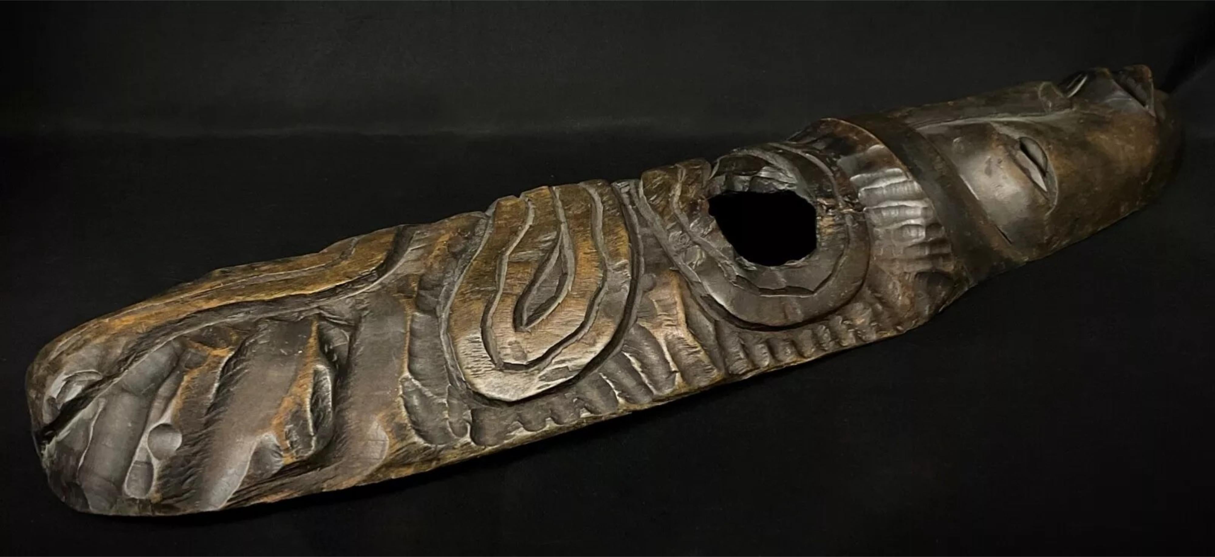 Questa grande maschera africana in legno dell'inizio del XX secolo è un'affascinante opera d'arte. Con un'altezza di 26,6 pollici (67,5 cm), una lunghezza di 17 cm (6,7 pollici) e uno spessore di 5 cm (2 pollici), questa elegante maschera pesa 1,502
