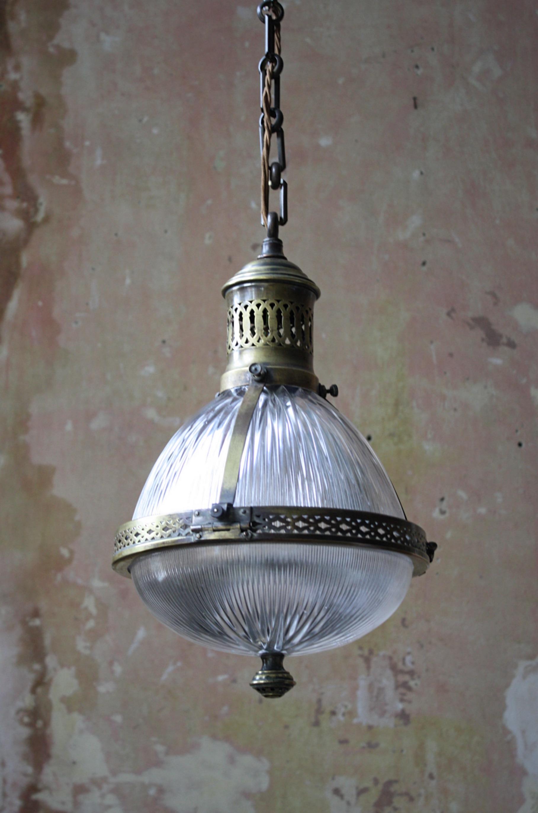 A rare caged French Holophane lantern.

The cage houses two sections of prismatic glass, with decorative pierced central band and gallery. The bottom diffusion plate has a pressed brass finial. 

All metal sections have age related oxidisation,