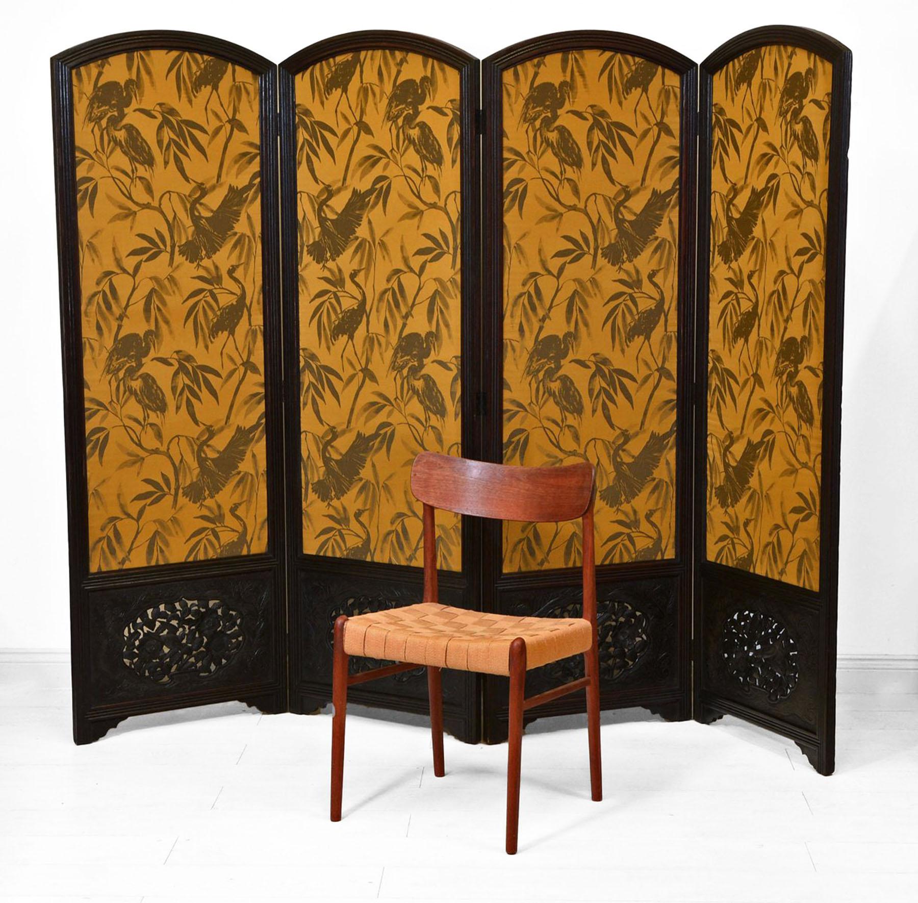 An antique large solid oak-framed four-fold screen with carved detail panels featuring birds and foliage. Circa 1920.

The fabric has been replaced with a vibrant Otori weave, featuring cranes perched among leaf fronds. 51% Polyester 25% Viscose