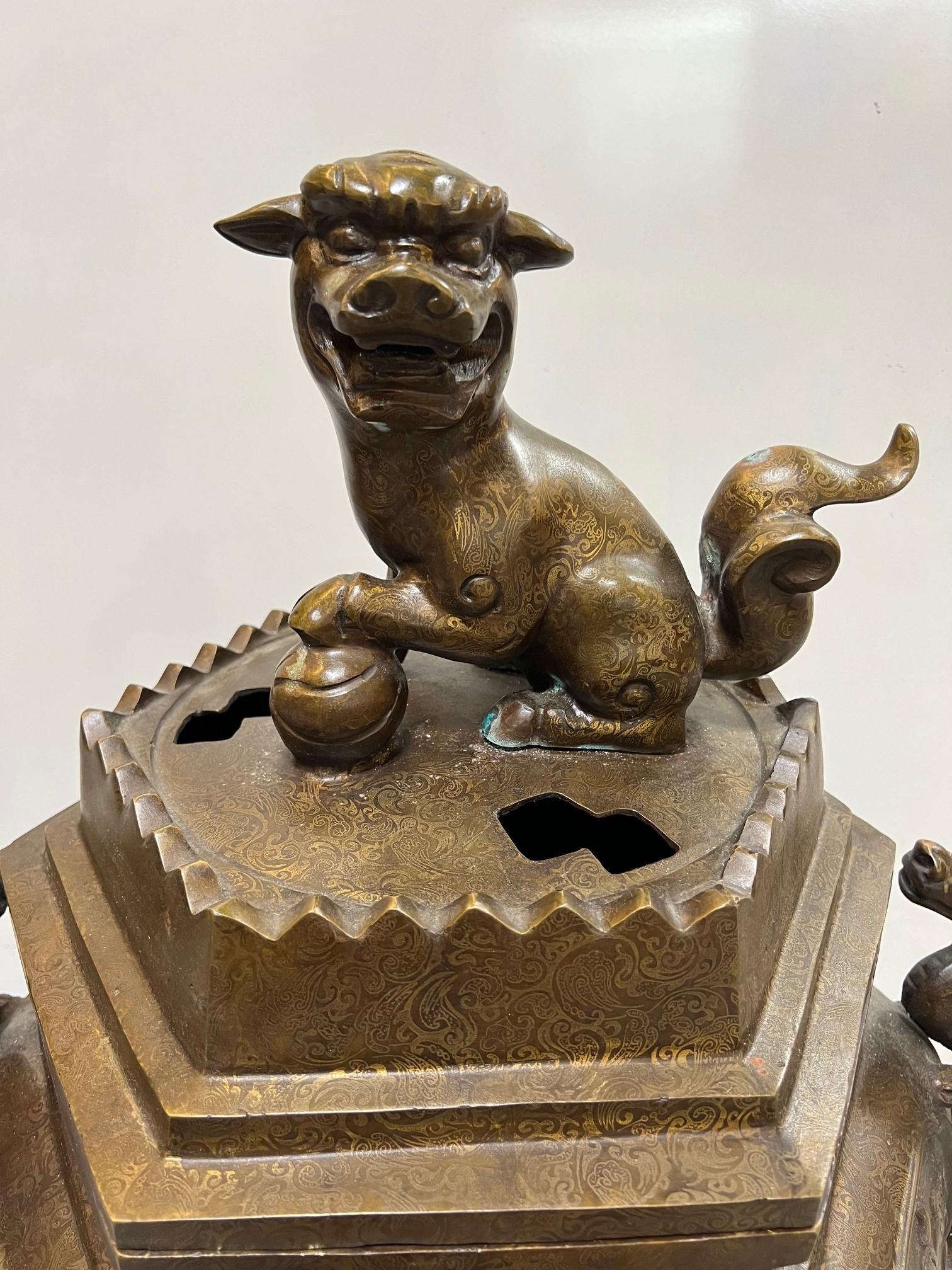 Early 20th Century large bronze censer on three legs with a foo dog sitting on top and Chinese dragons on each side. Censers also known as incense burners, have a long history in China, dating back to ancient times. They were used for a variety of