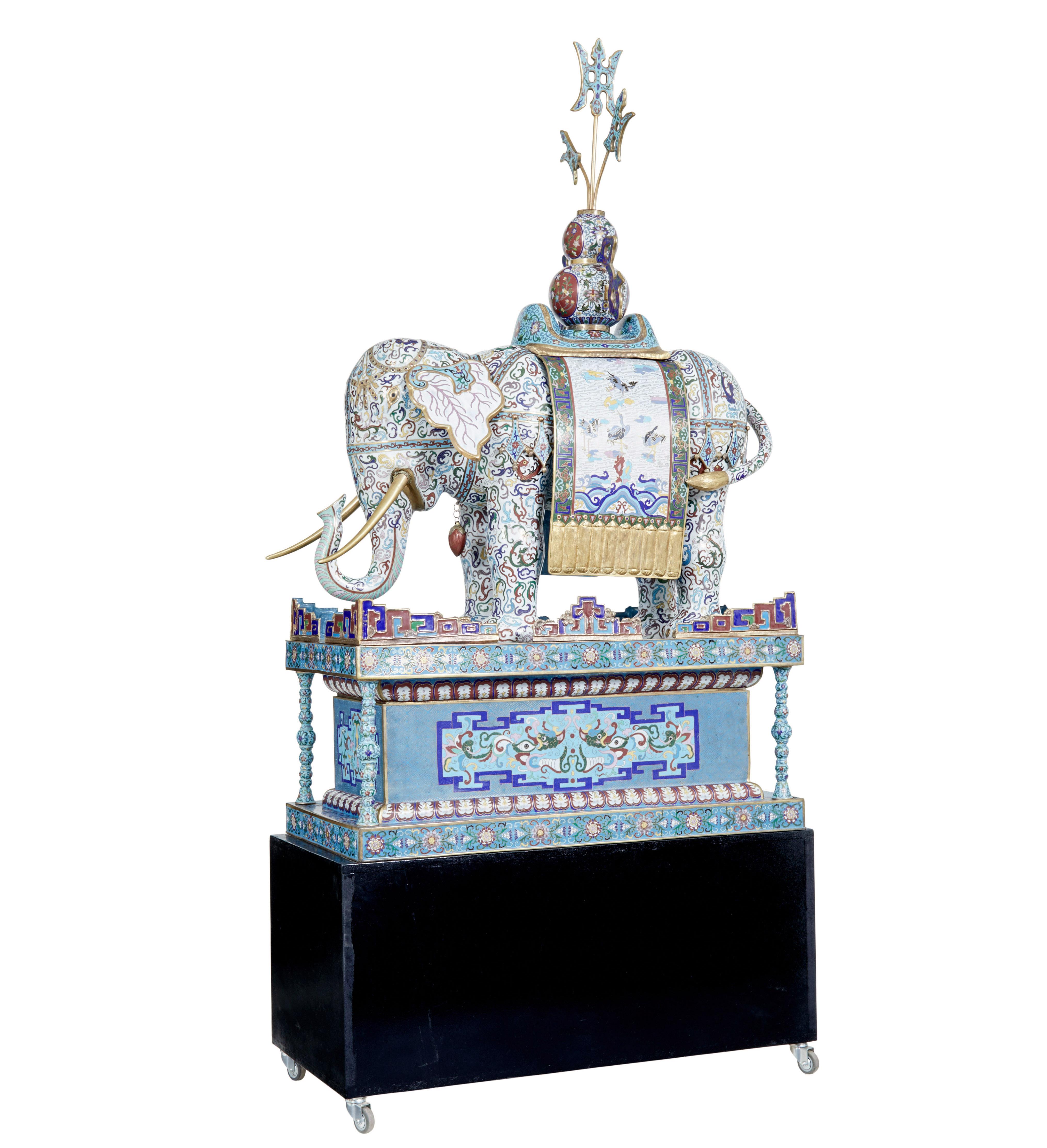 Grand éléphant chinois en émail cloisonné du début du 20e siècle, sur socle, vers 1900.

Une pièce décorative très rare.

Profondément émaillée, elle porte une selle et un épi de faîtage flamboyant.  Incrustée sur toute sa surface de rinceaux et de