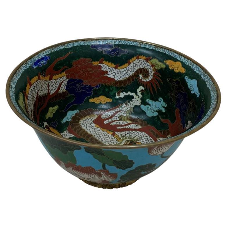 A large Cloisonné enameled early 20TH century Chinese bowl decorated with Lotus flowers on the exterior. The interior is decorated with a fierce five clawed dragon amidst clouds. Beautiful and bright colors. Dimensions 14.75-inch diameter at the