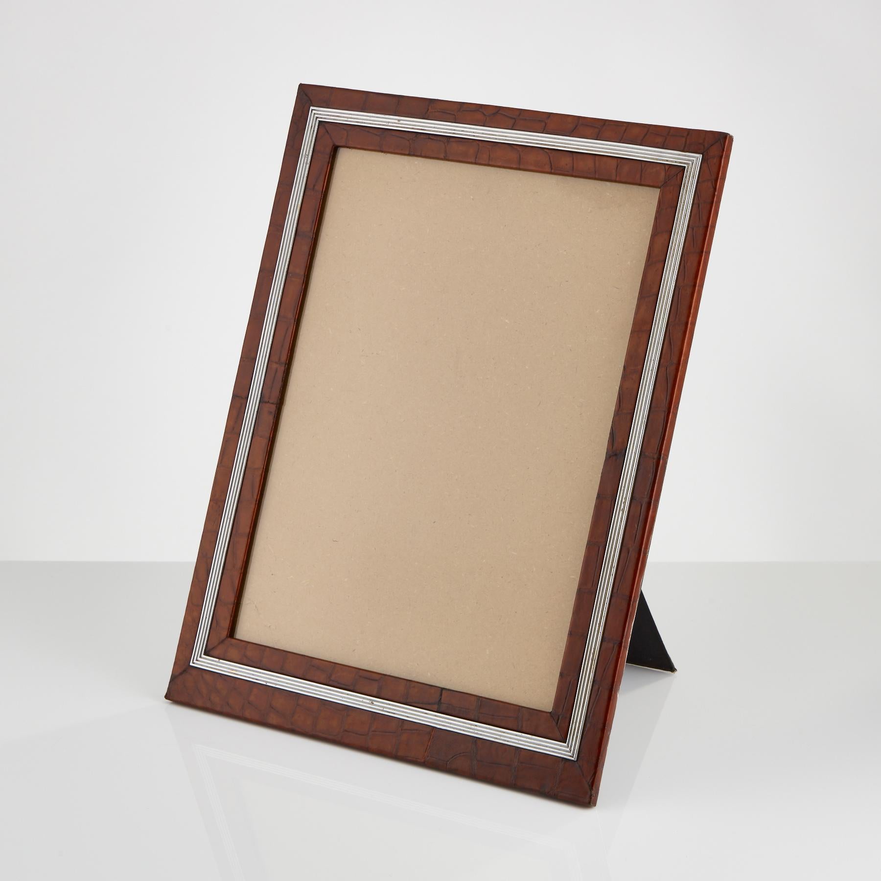 An early 20th century large crocodile photo frame with applied ribbed border, circa 1910-1915
The fine crocodile skin is in excellent condition and the colour is called London tan.
Also retains its original back and strut.