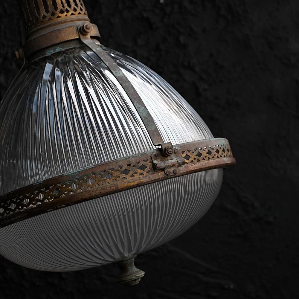Early 20th Century Large Holophane Pendant Light 

A large example of an early 20th Century Holophane pendant light. Constructed of hand cut glass and brass. With a natural deep patination covering the metal area of this highly decorative interior