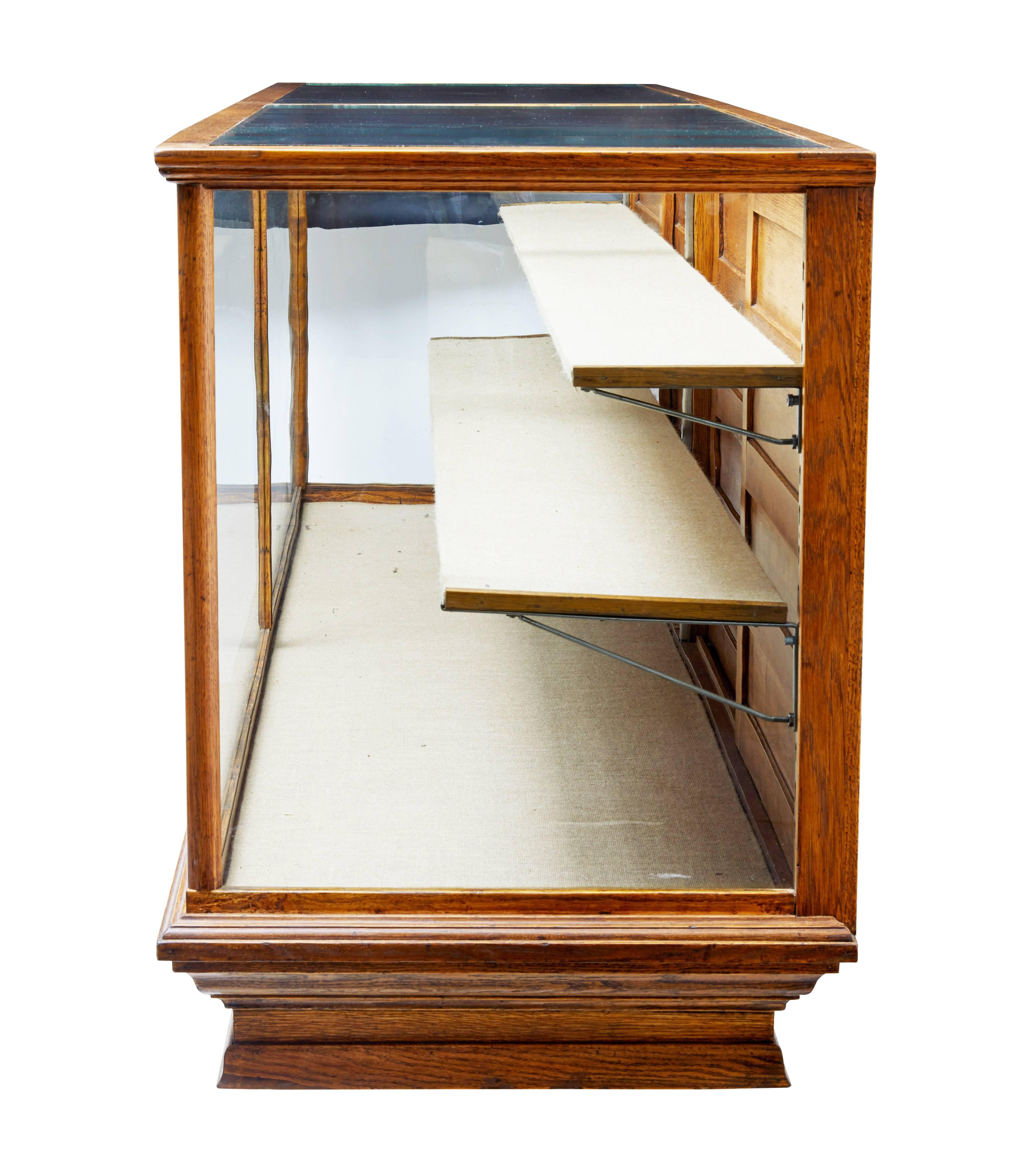 Fantastic haberdashery display cabinet of large proportions, circa 1910.

Glazed front, sides and top surfaces. Two adjustable shelves and base display area which is hessian covered.

To the back are 4 sliding doors which allows access to the