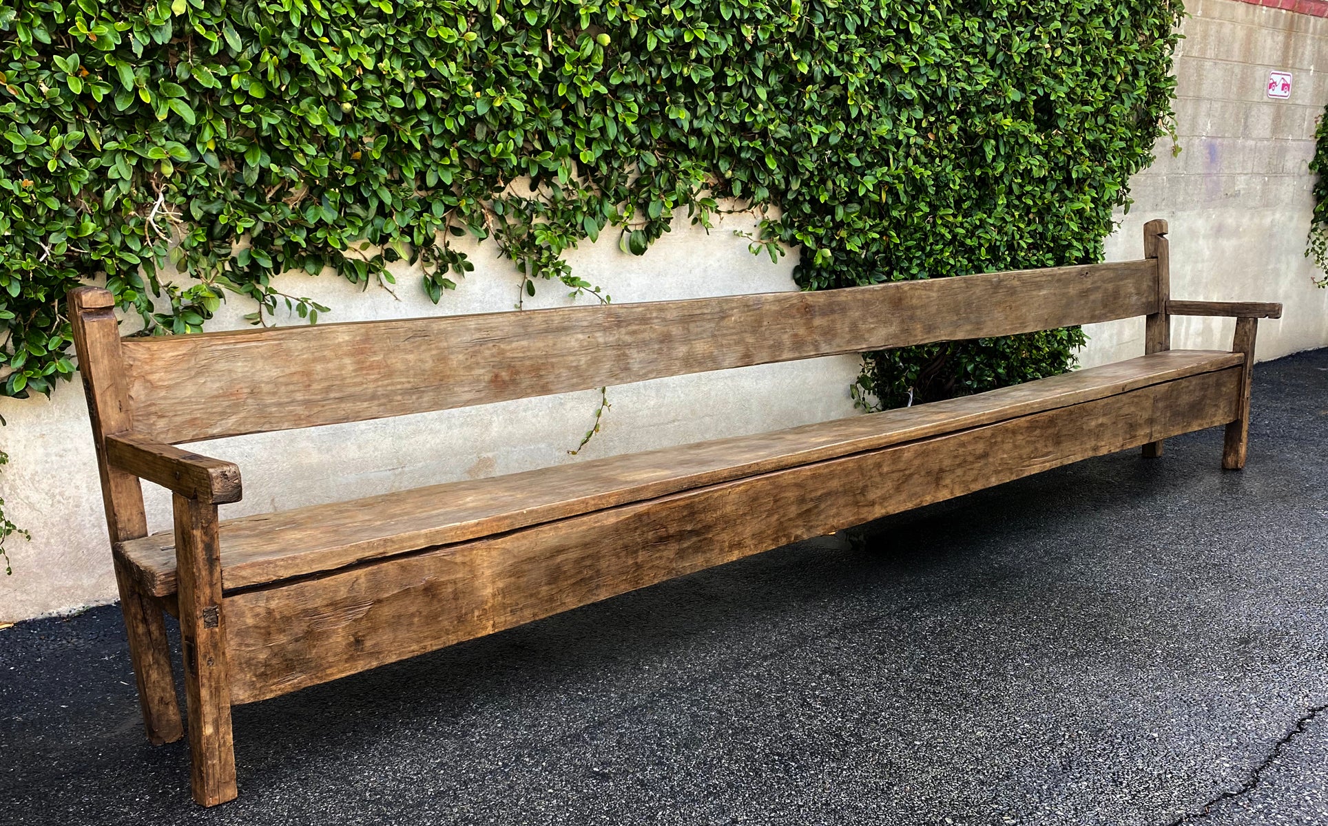 This bench is unusual in the 15 foot length. It was part of a Holy House in Todo Santos, Guatemala where the Cofradia ( a religious fraternity or sorority) would meet. It has a table matching in length that was with it in the Cofradia. This rustic