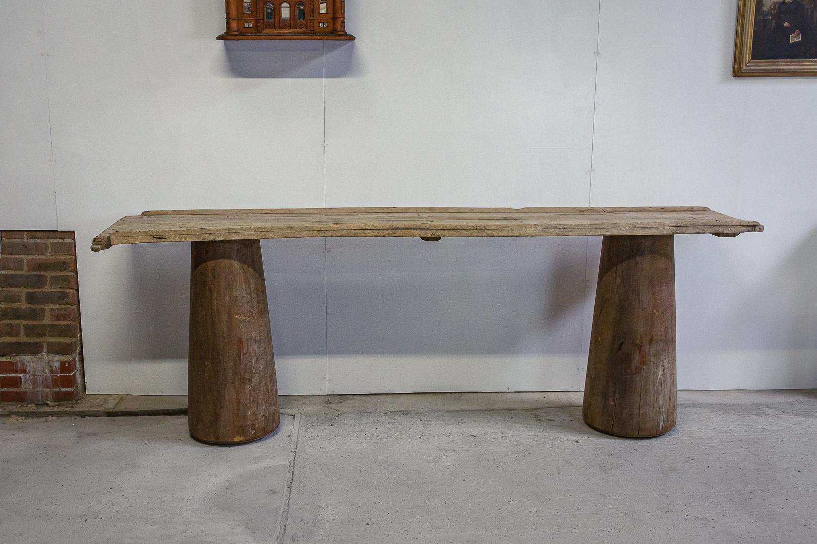Large scale timber trunk or pillar console table, hardwood timber tapering pillars, the top is a reclaimed grain slide used for sliding sacks of grain from the first level is a storage barn, this has given it a wonderful dry, pale, worn sun bleached