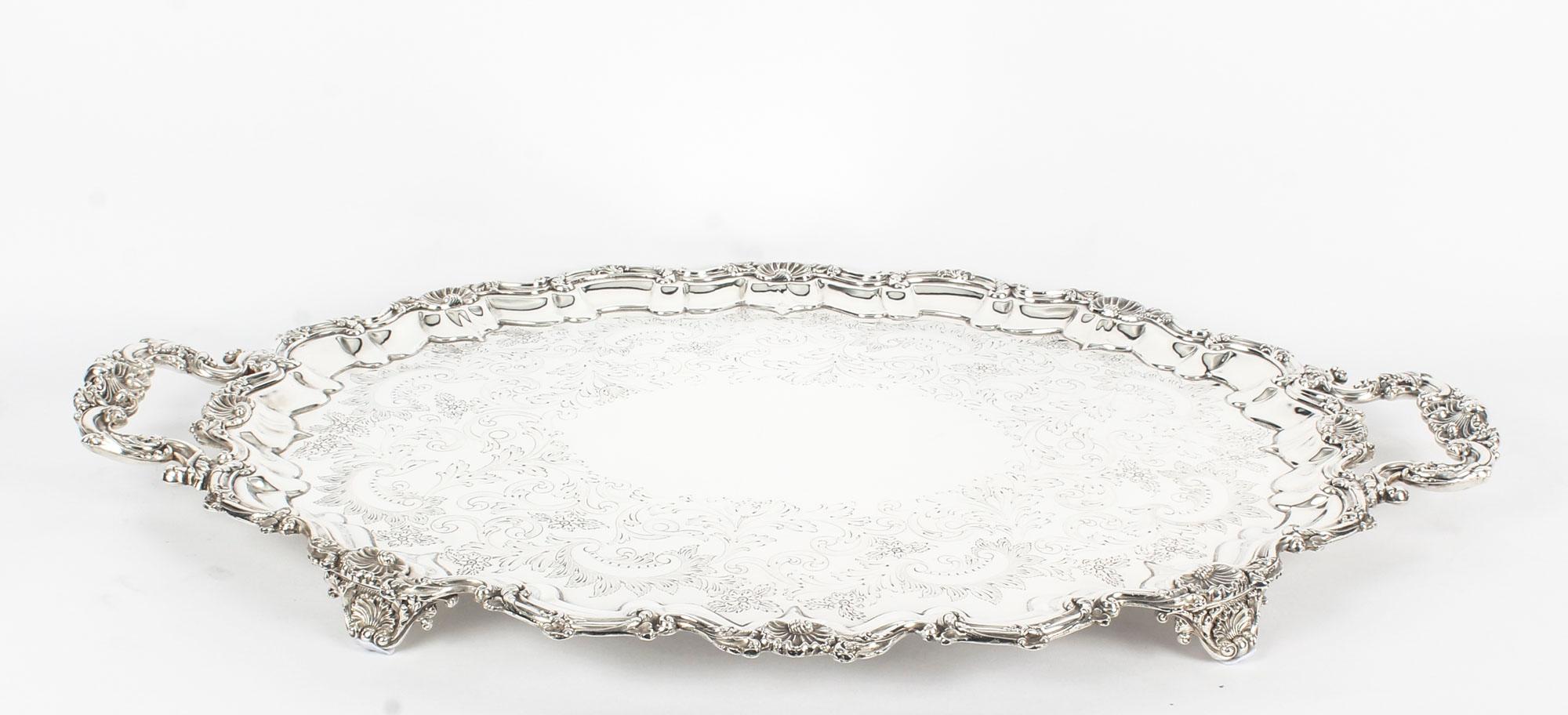 This is a lovely antique large English Victorian silver plated tray with makers marks dating it to circa 1908.

This large oval silver plated tray features fabulous engraved decoration, a deep set decorative reeded border with elegant handles to