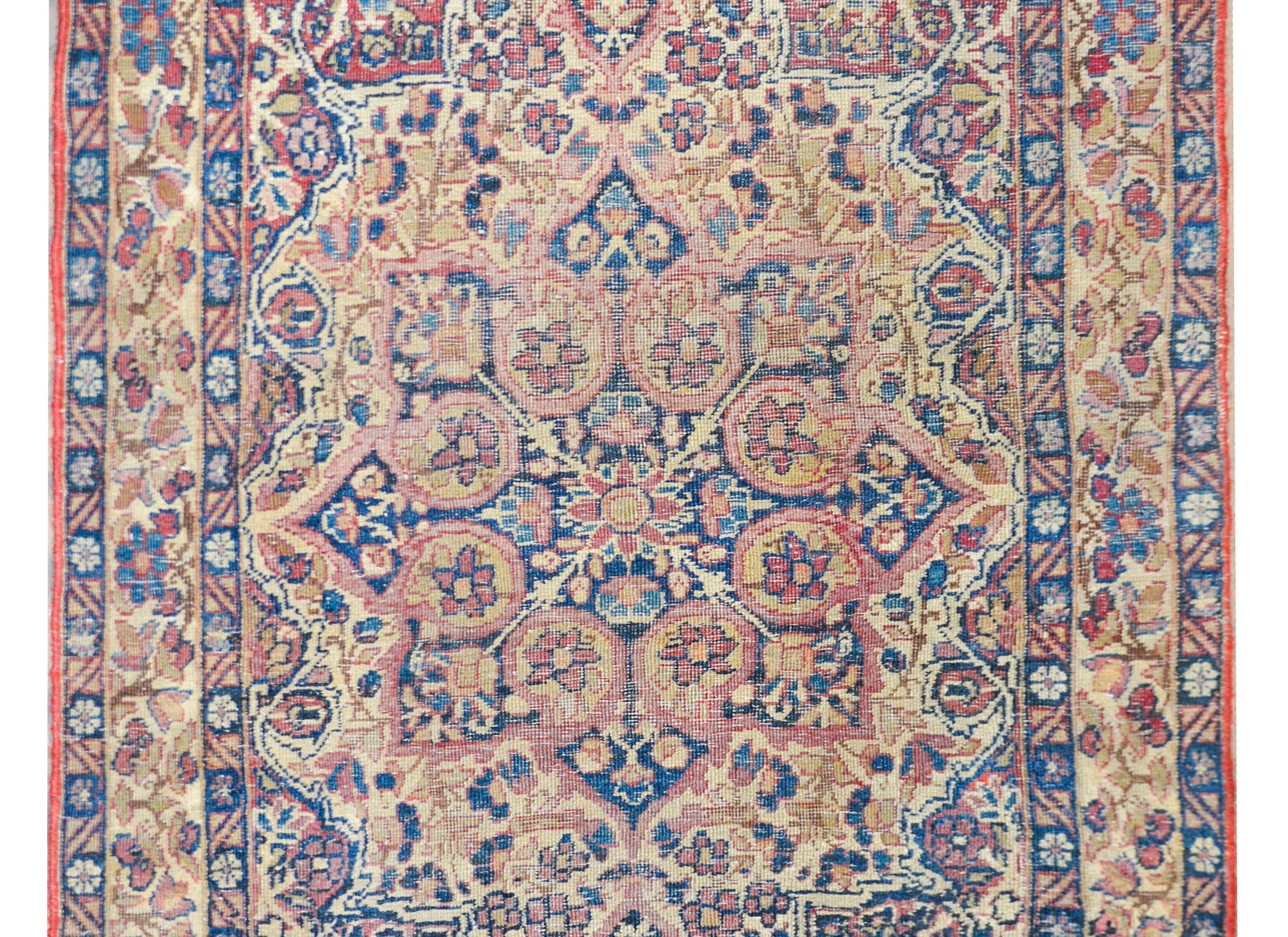 Magnifique tapis persan Lavar Kirman du début du XXe siècle, avec un motif traditionnel contenant un médaillon central à huit lobes avec une myriade de petites fleurs et de vignes défilantes, et tissé dans les couleurs traditionnelles Kirman de