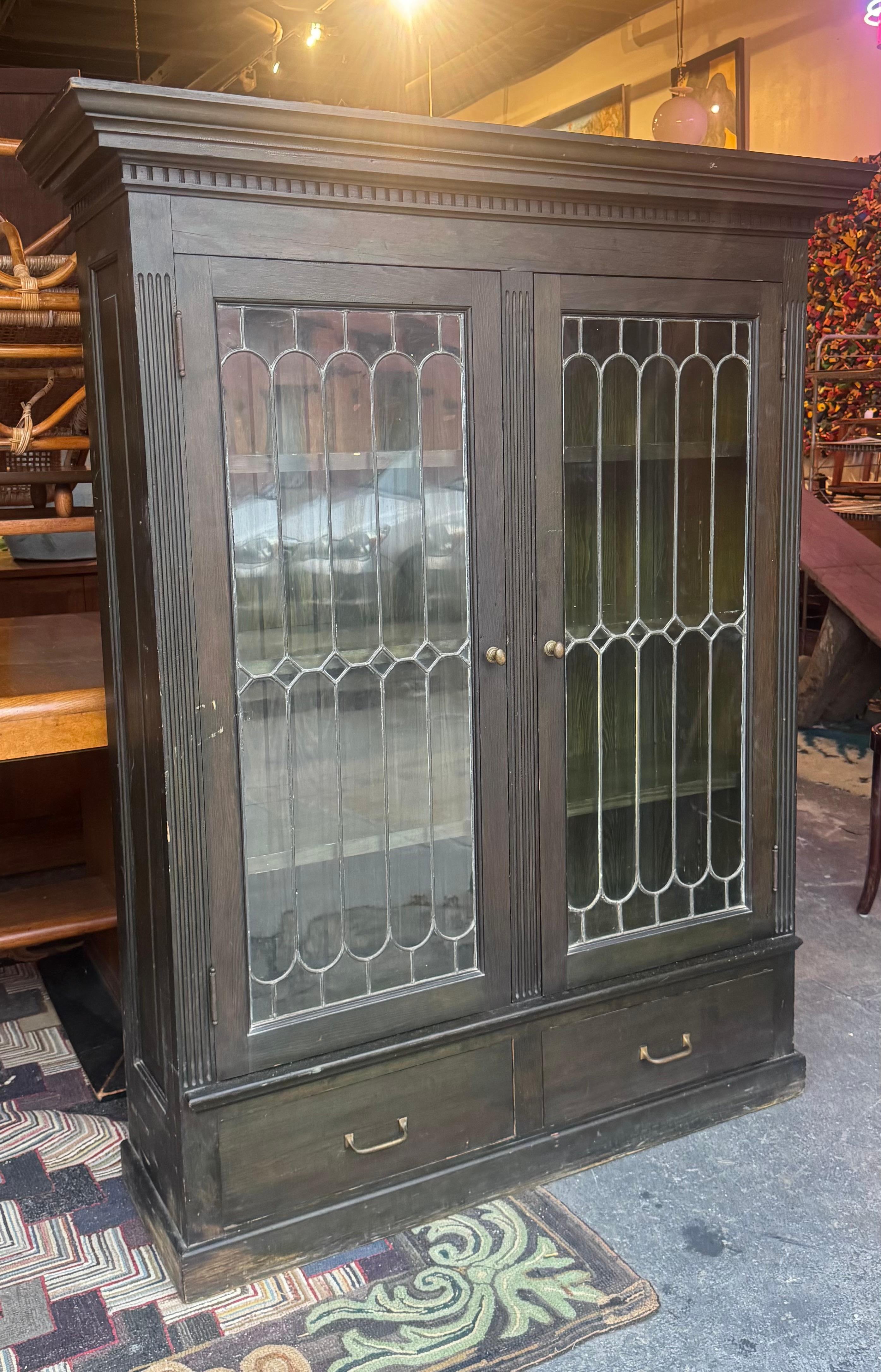 Libreria/vetrina in legno e vetro piombato dei primi del Novecento, con schienale in perline e interni tinti di un originale verde anilina  Design classico (quasi Art Nouveau),, Due ante su tre ripiani regolabili,,  Due cassetti inferiori...