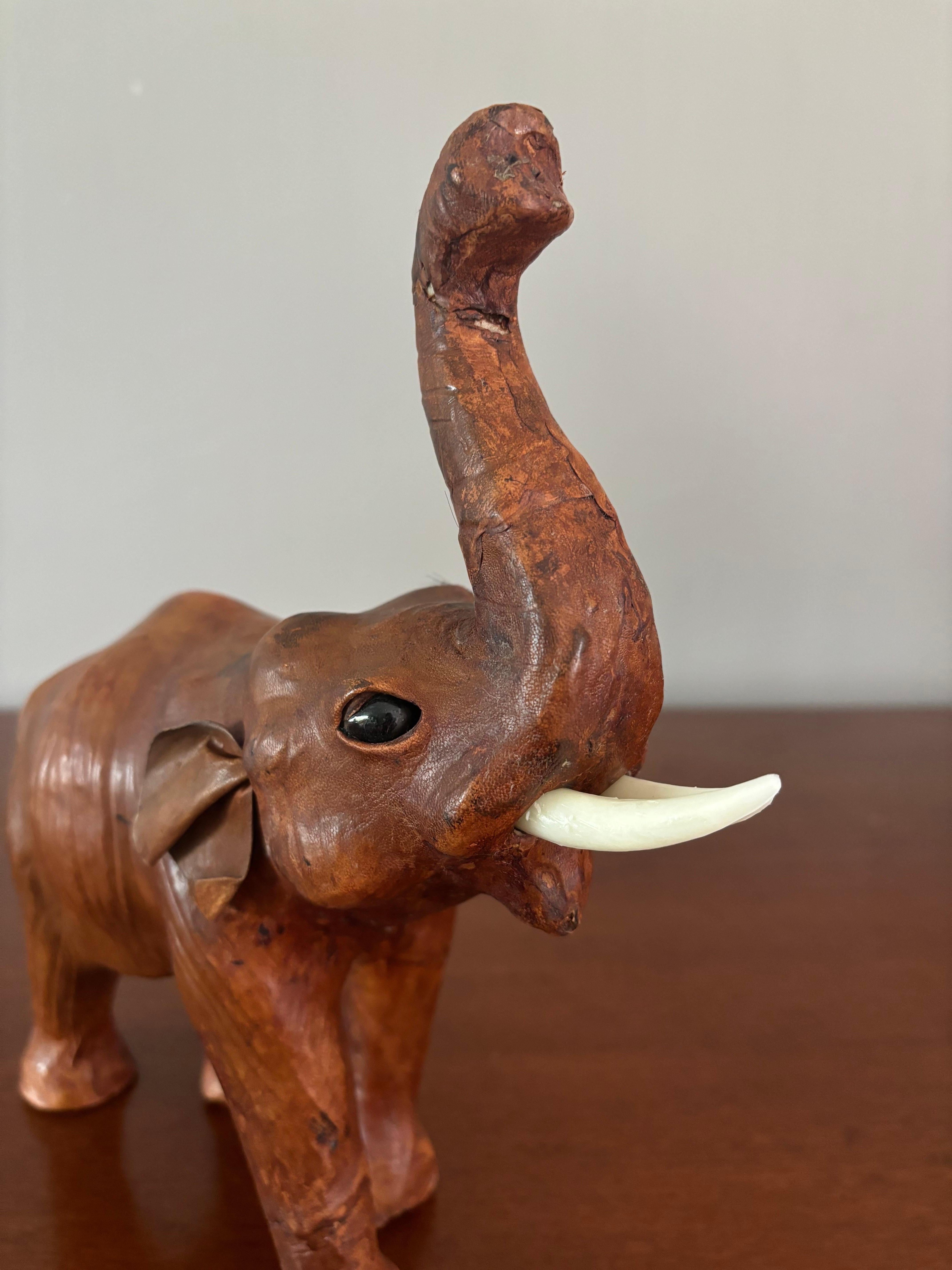 Sculpture d'éléphant en cuir faite à la main. Etat original. Probablement une importation de l'époque anglo-indienne. Fausses défenses en ivoire. 

Il ferait un bel ornement sur une étagère ou un bureau. S'intègre bien dans les motifs traditionnels,