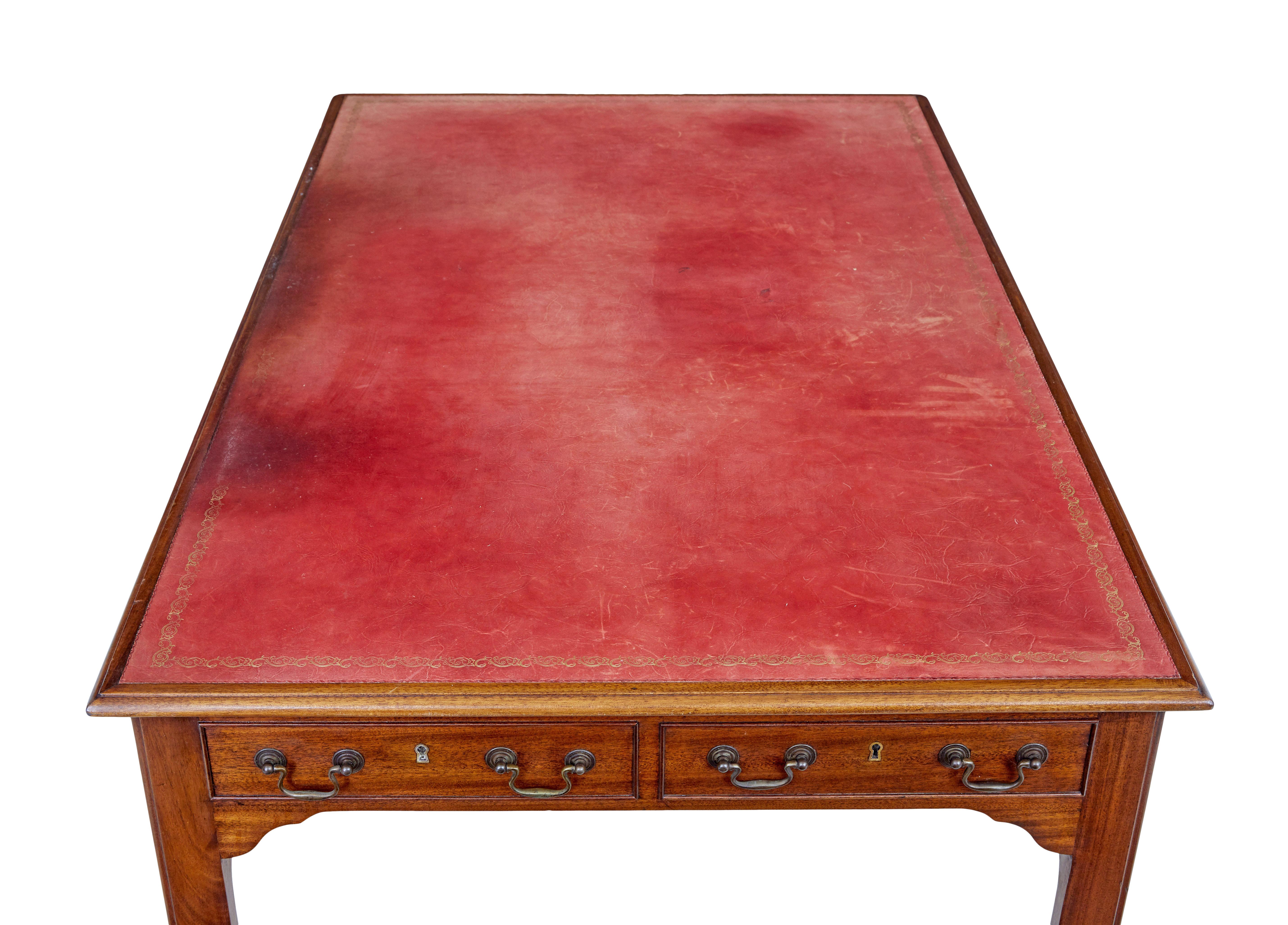 Early 20th century leather top mahogany desk circa 1910.

Original red leather writing surface with gold tooling, with obvious signs of use.  Fitted with 3 drawers above the the knee for storage, desk is fitted with dummy drawers on the back and