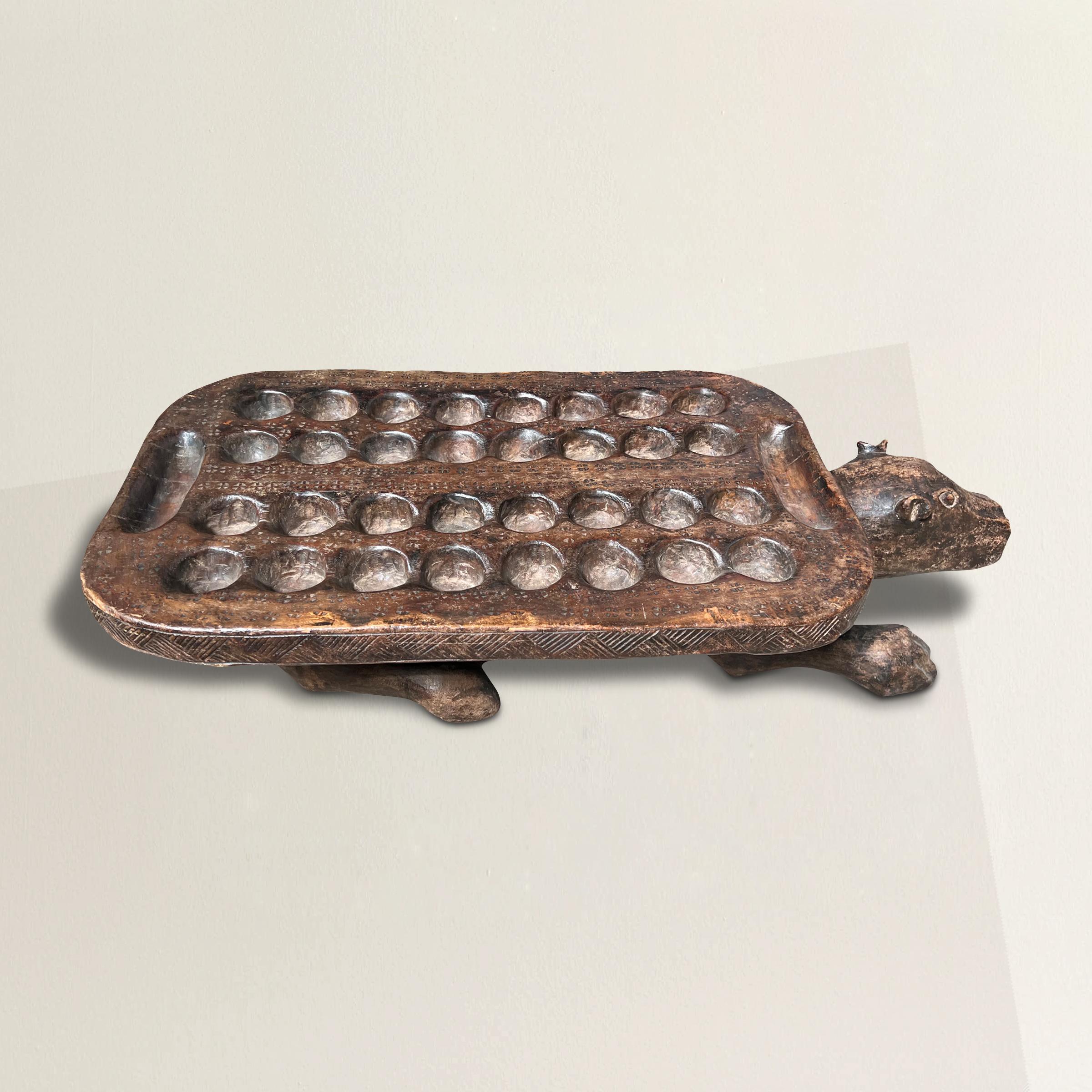 A whimsical and playful early 20th century leopard-form mancala game board carved with the board resting on the leopard's back and with a patina that only a hundred years of use could bestow.  A hole on the side of the leopard originally held the