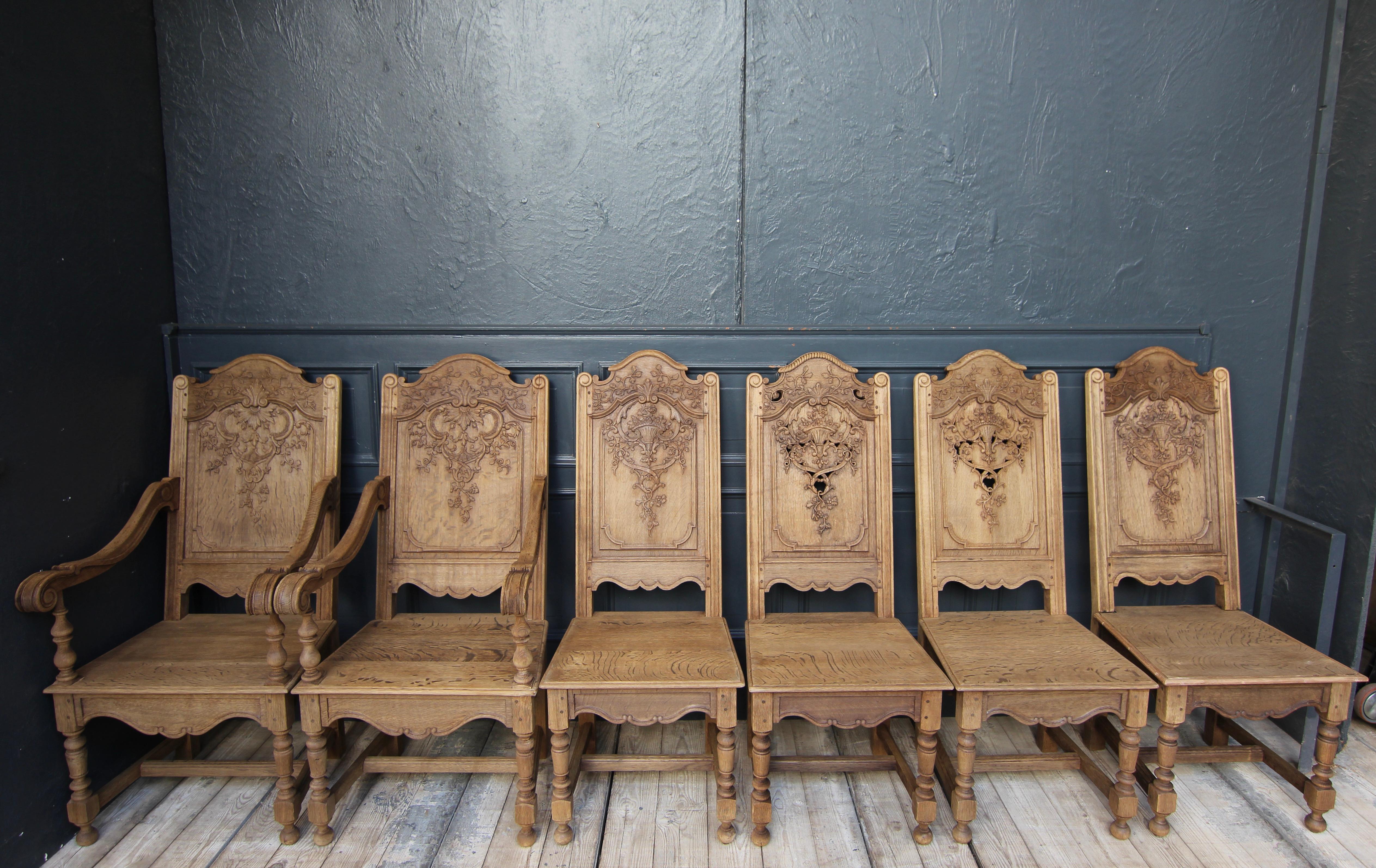 Stunning set of early 20th century Liege dining chairs. Two armchairs (fauteuils) and 4 chairs without backs. Solidly made in oak and carved ornamentally, as well as florally and with rocailles.

The wood has been stripped of the old wax,