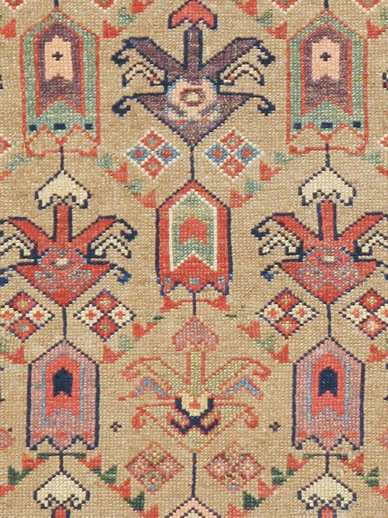 An antique Persian Serab runner from the early 20th century. This Kurdish village rug displays a hexagonal lattice in three columns with large, bug-like palmettes on a camel-brown field. The tonally matching main border has detached octagons. The