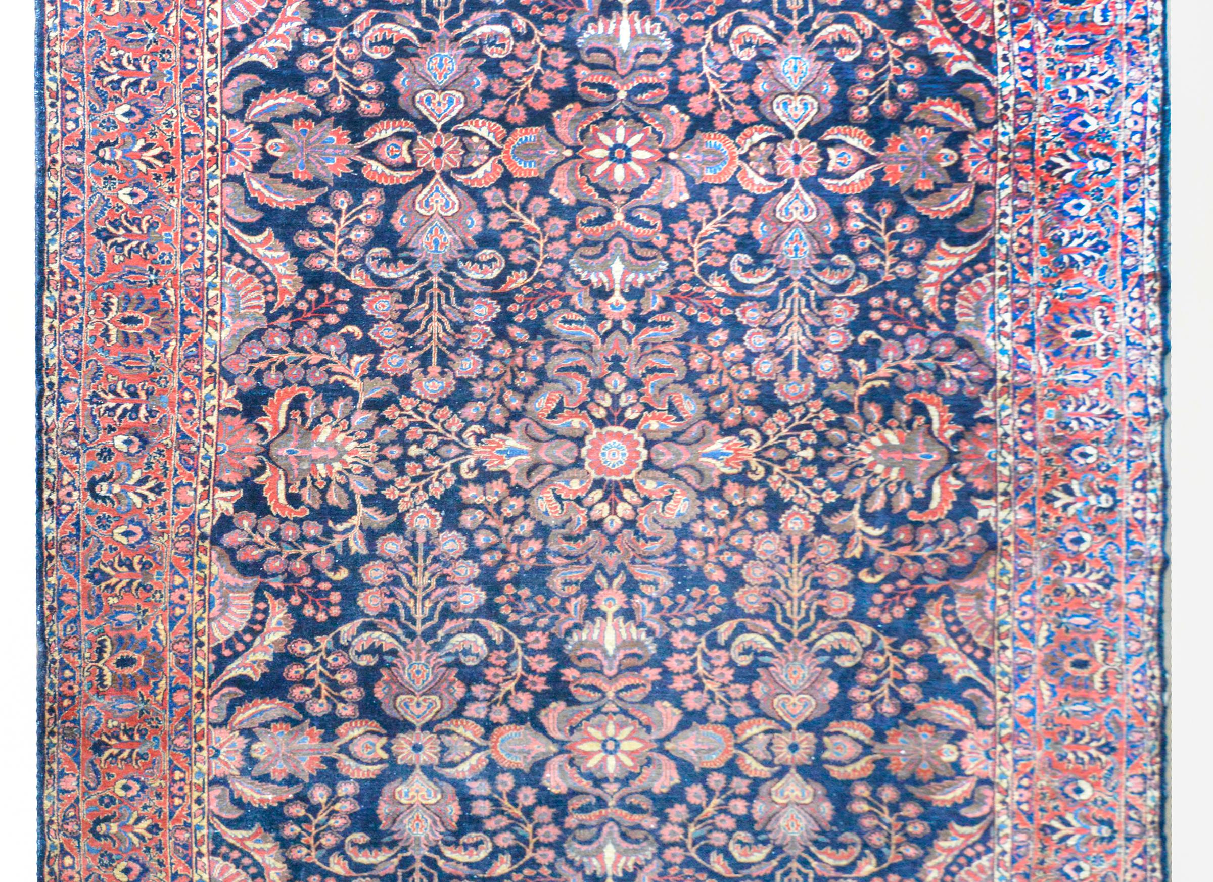 An incredible early 20th century Persian Lilian rug with a beautiful all-over mirrored floral pattern woven in traditional Lilihan colors of light and dark indigo, crimson, cream, and pink. The border is outstanding with a wide central floral