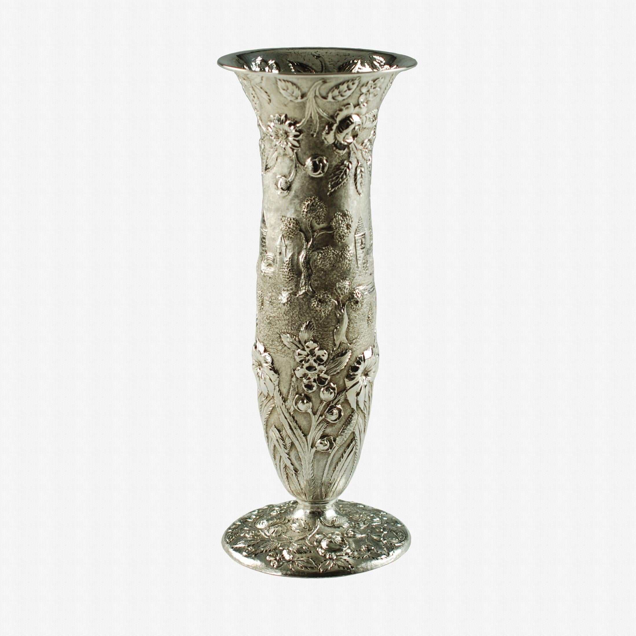 This elegant early 20th century sterling silver bud vase has a traditional trumpet form with a wide pedestal base and has been finished in the highly desirable Castle pattern. The ornate repoussé decoration consists of detailed roses and foliage on