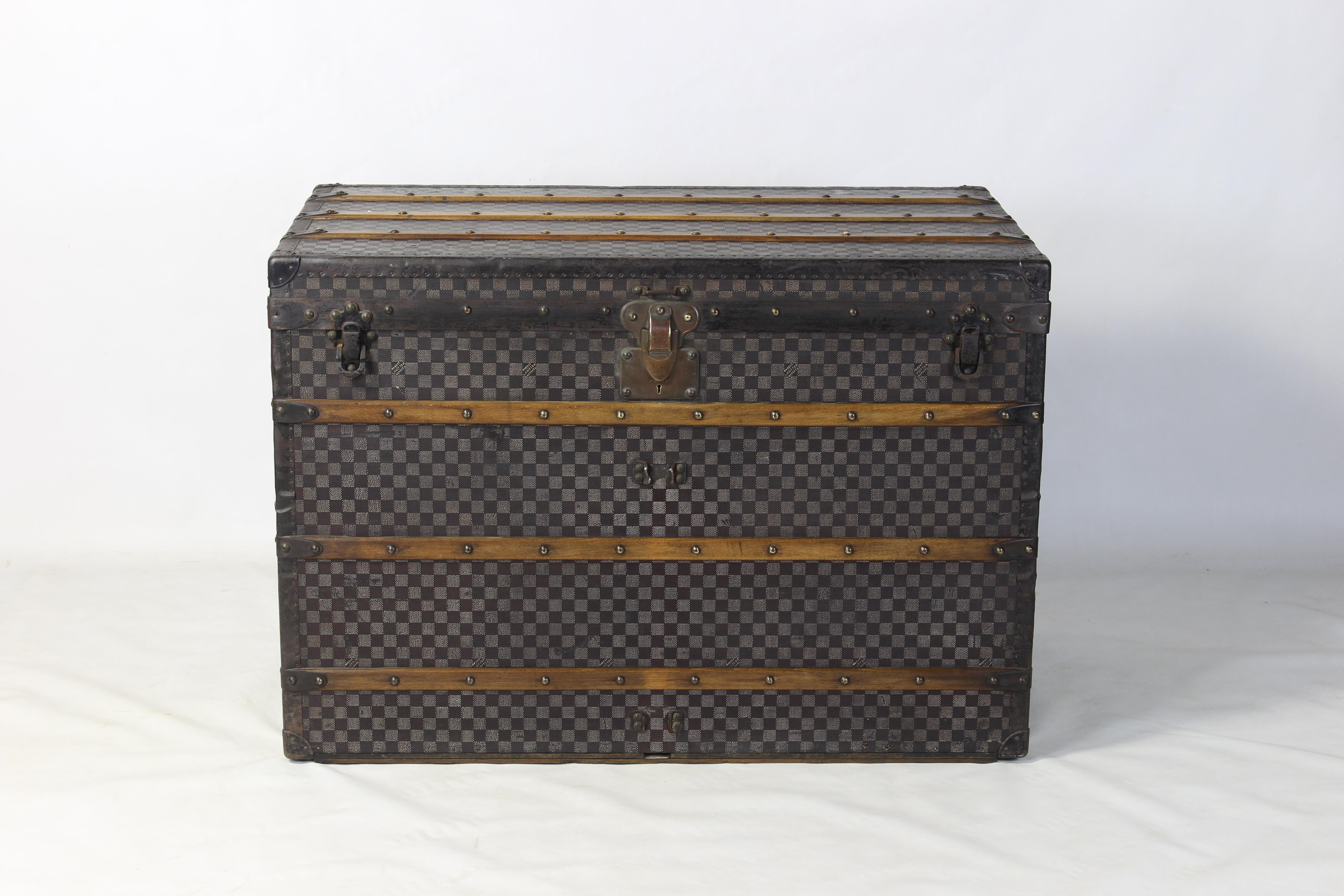 A large and impressive Louis Vuitton Damier steamer trunk, circa 1905. The rare checkerboard pattern with steel hardware and steel handles is in excellent condition for its age. The trunk is complete with its large original interior label and three