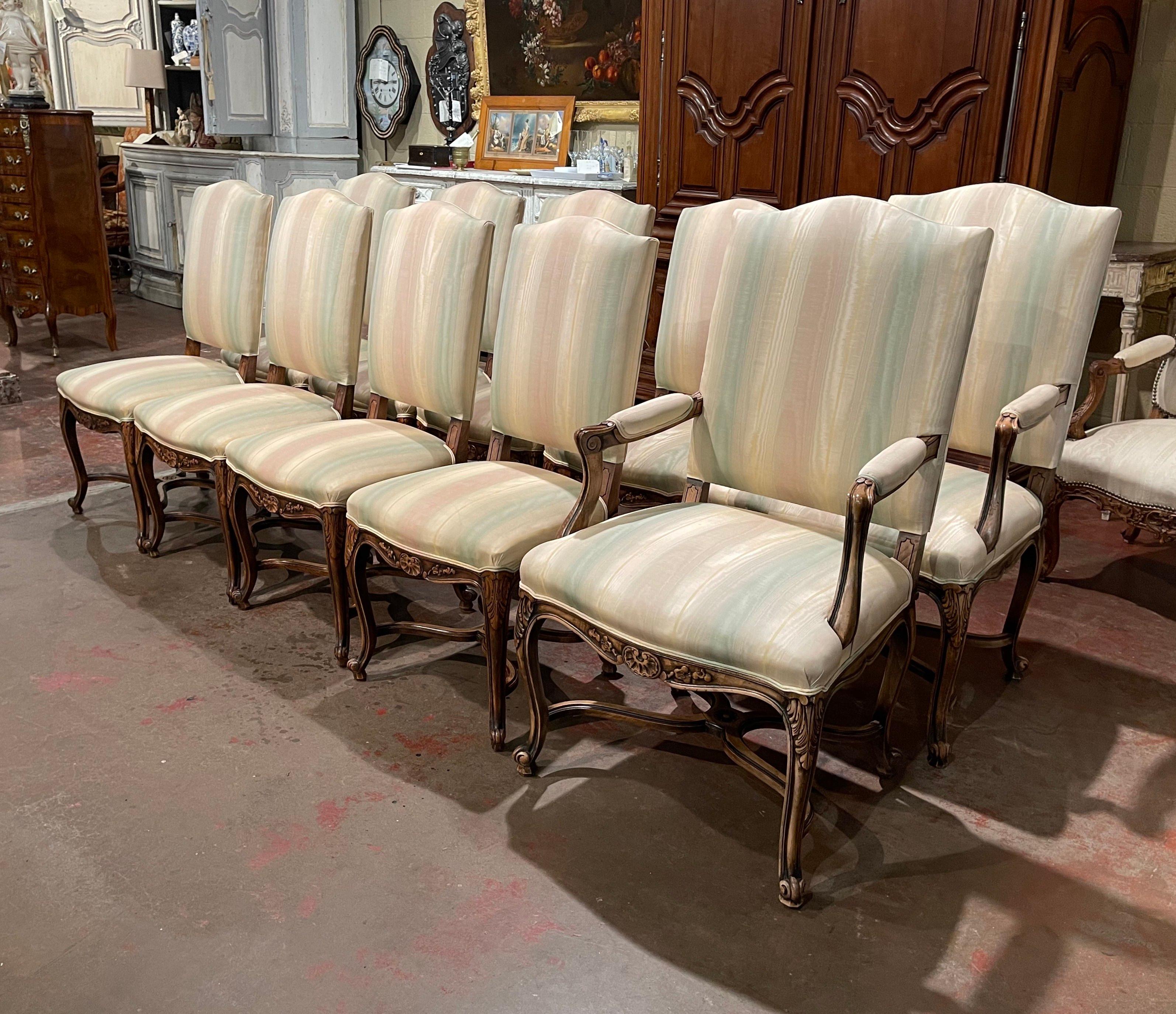 Decorate a dining table with this elegant suite of ten dining chairs and matching armchairs. Crafted in Provence, France circa 1920, each piece stands on cabriole legs decorated with acanthus leaves at the shoulder and ending with escargot feet,