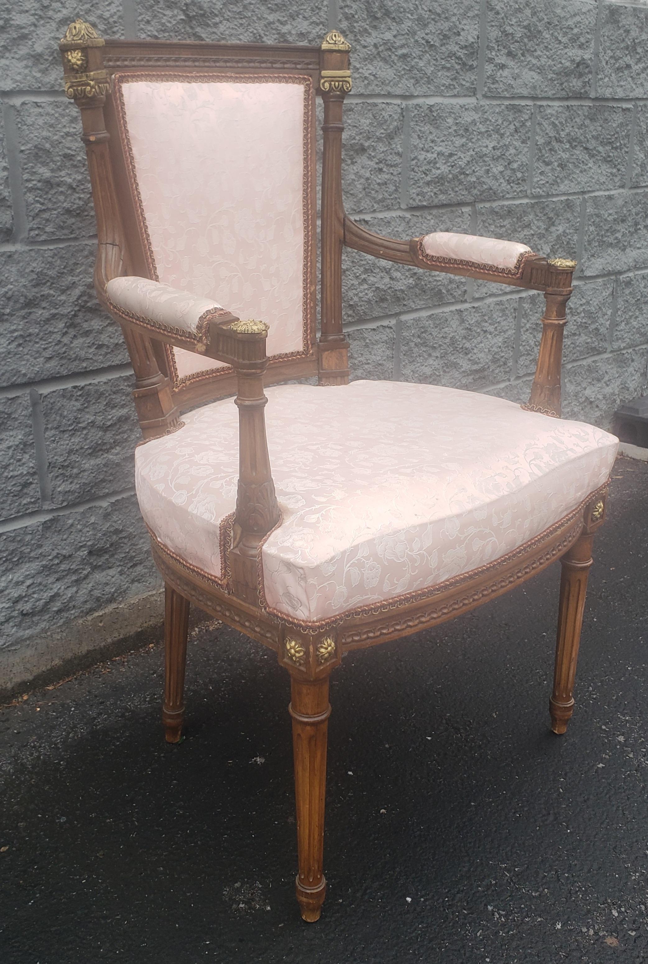 An early 20th century Louis XV mahogany and giltwood upholstered armchair in good condition with rose color upholstery. Chair measures 23