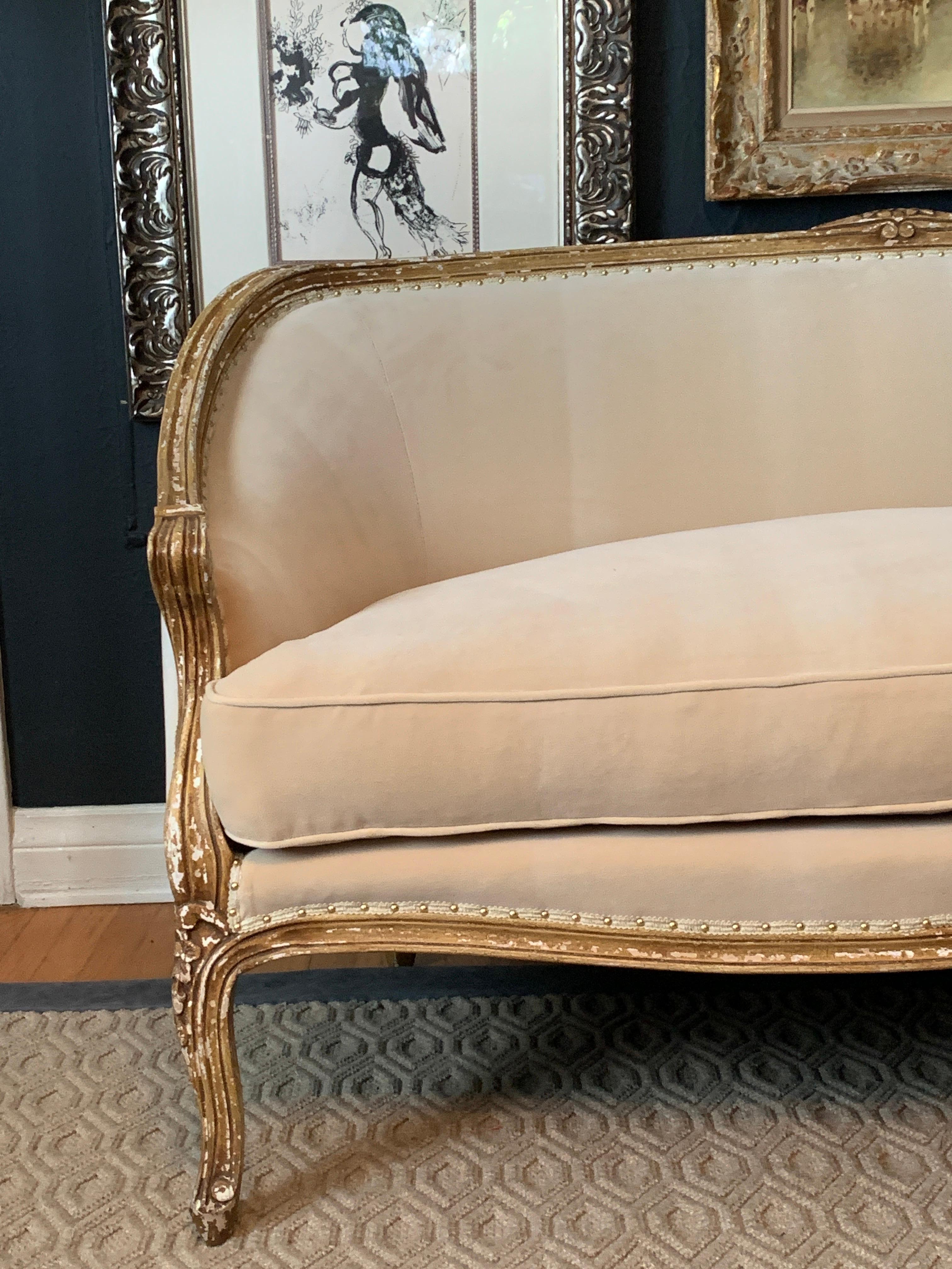 Very chic early 20th century Louis XV settee or love seat. The wonderfully patinated wood silhouette is very clean and sexy with a very stable frame. Upholstery is new Belgian Velvet with a clean gimp and brass nail heads (see attached images). The