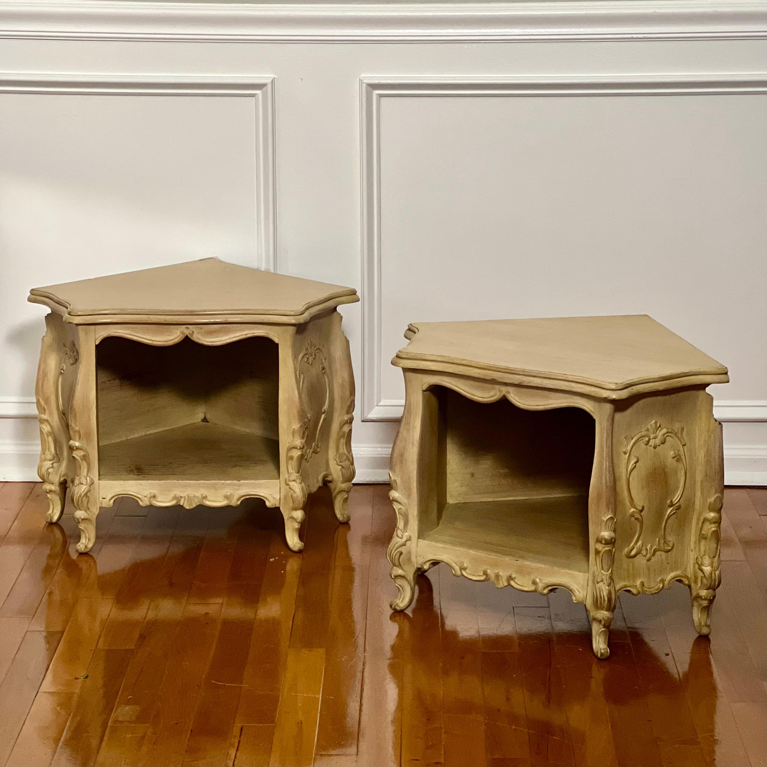 Paire de petites tables d'angle de style Louis XV, sculptées et peintes en crème, avec placard ouvert.

Unique en son genre, ce meuble présente une forme galbée ornée d'un tablier festonné et de sculptures ornées de feuilles d'acanthe et de fleurs