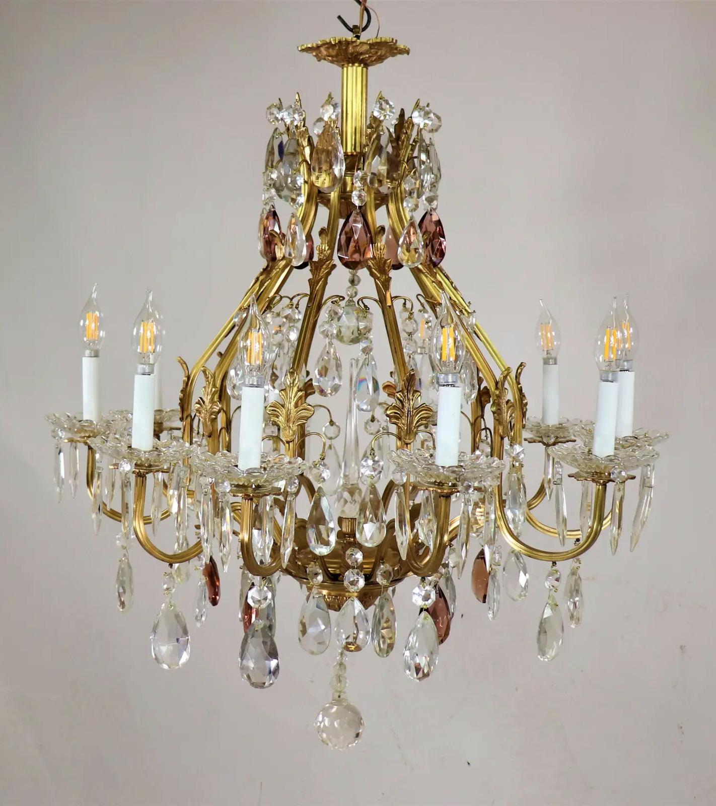 An early 20th century Louis XV style doré bronze and brass with birdcage chandelier adorned with bronze acanthus leaf appliqués throughout the frame. Doré (gilt bronze or brass) is a technique that leaves a layer of gold on bronze and brass. It