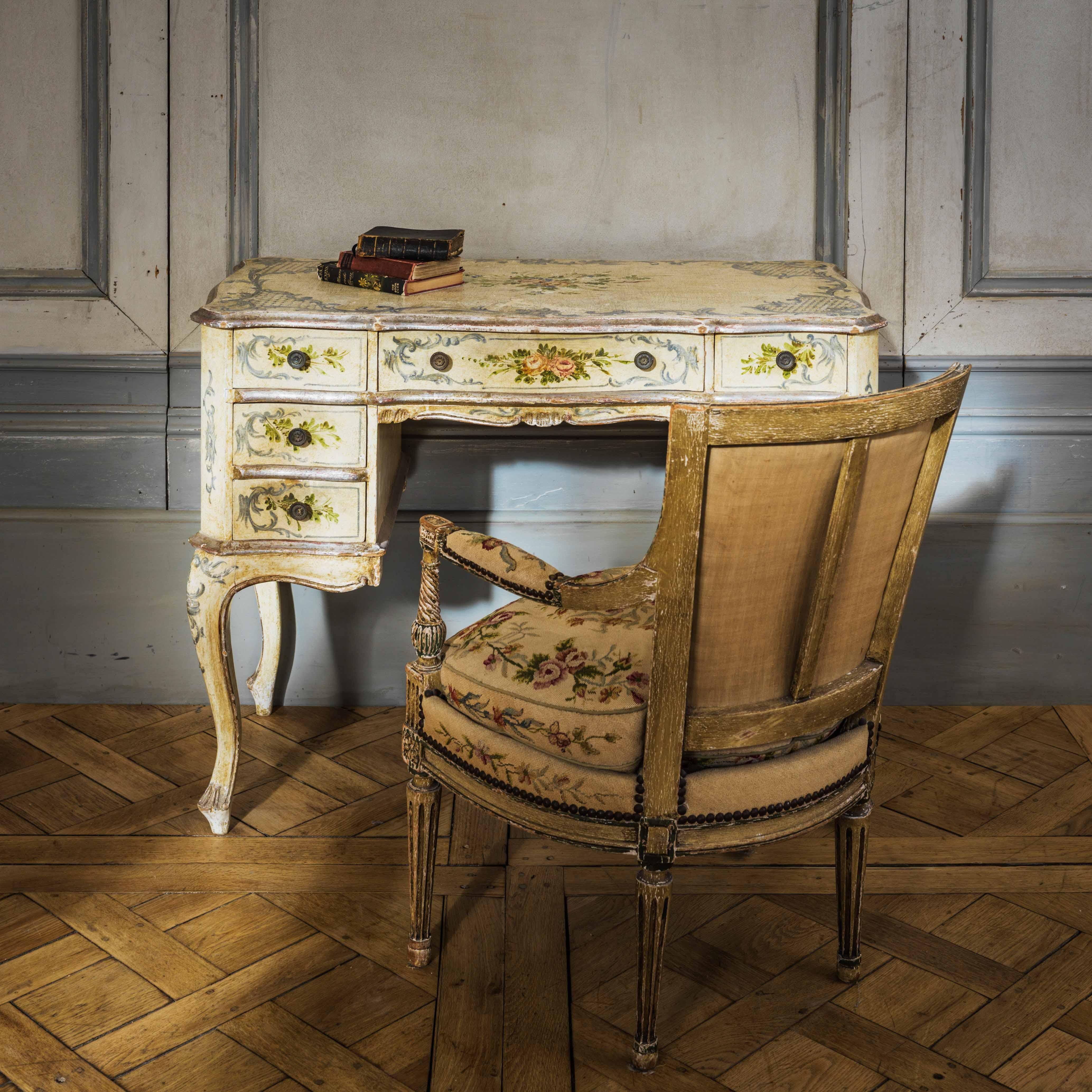 A charming, hand-painted, Louis XV style, Italian writing desk or dressing table from the early 20th century depicting floral motifs with Rococo flourishes and gilded highlighting.