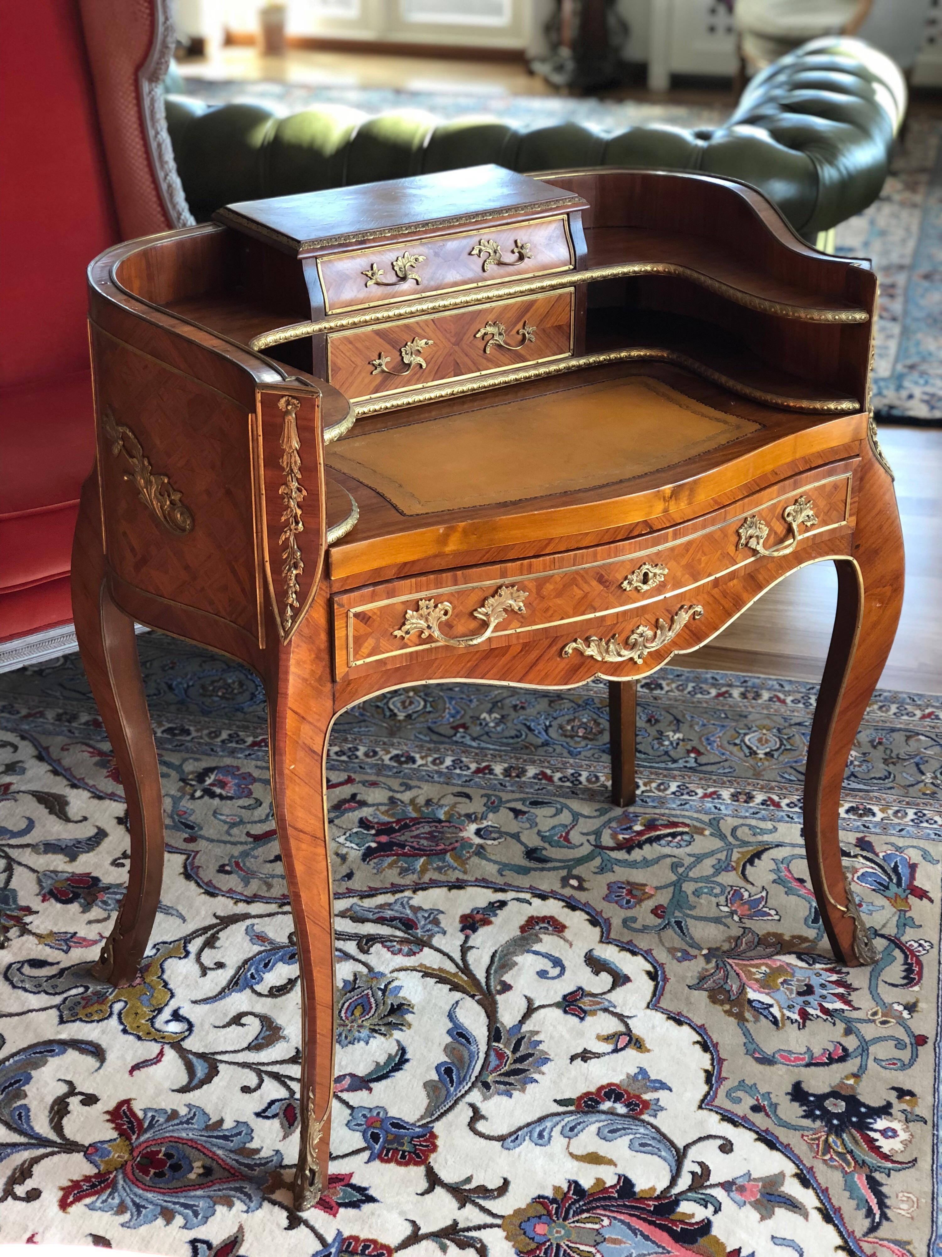 Small ladies secretary animated form of veneer wood and rosewood marquetry, opening to two drawers in step. Bronze ornaments, pull handles the removable tray covered with leather, curved legs ending in golden bronze shoes, Louis XV style, early 20th
