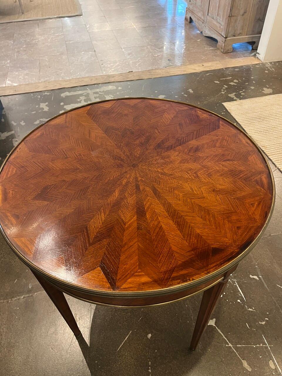 Mesa Bouillotte Luis XVI de principios del siglo XX con marquetería incrustada, parquetería en diseño de espiga con galería de latón.
Algo de decoloración del acabado en la parte superior, intenté que se viera