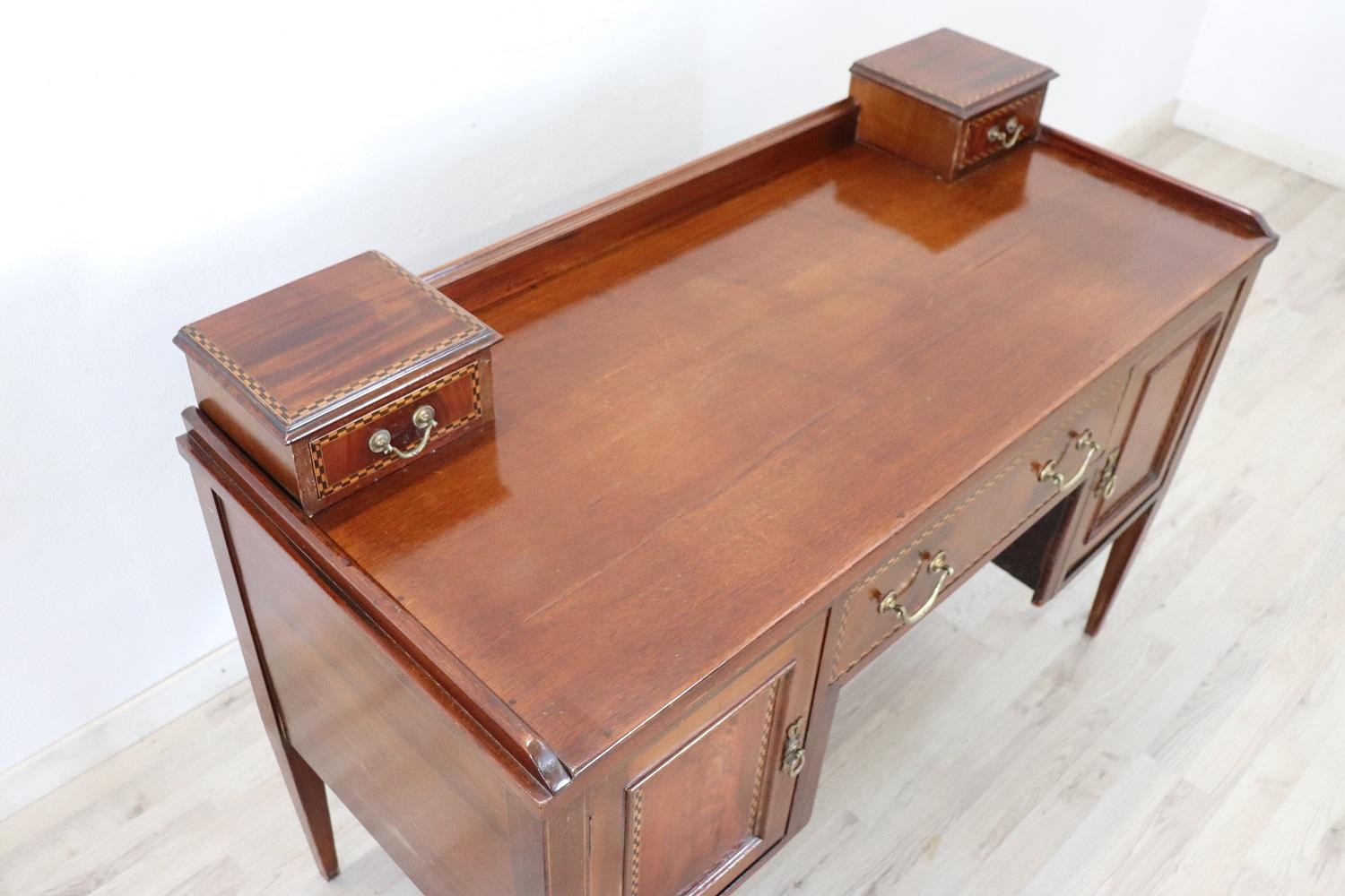 Early 20th century beautiful italian Louis XVI style writing desk. In precious mahogany wood with refined geometric inlay decoration. The very simple line equipped with drawers and doors.