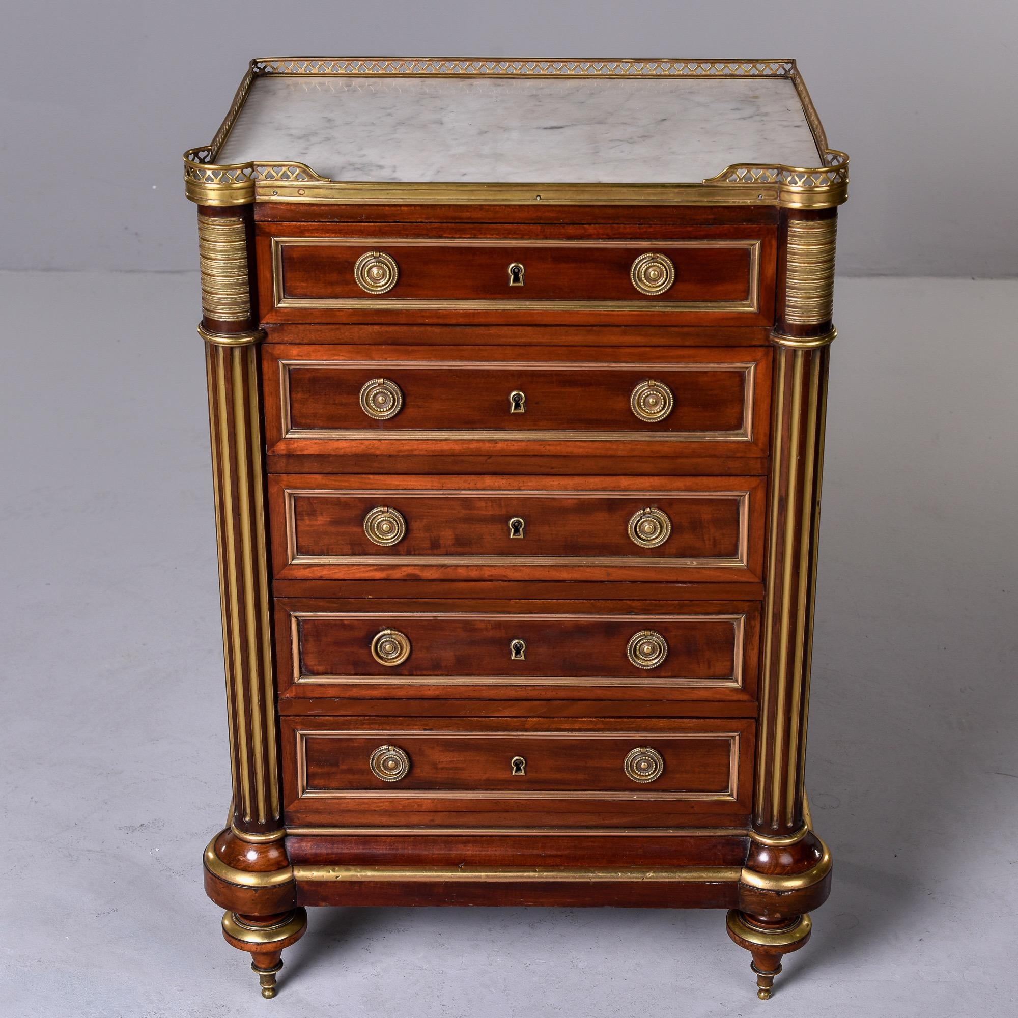 Circa 1900 five drawer Louis XVI style mahogany semanier features a white marble top, brass gallery, brass hardware and trim. Drawers have dovetail construction and escutcheons but no key was found or included with piece. Unknown maker. Very good
