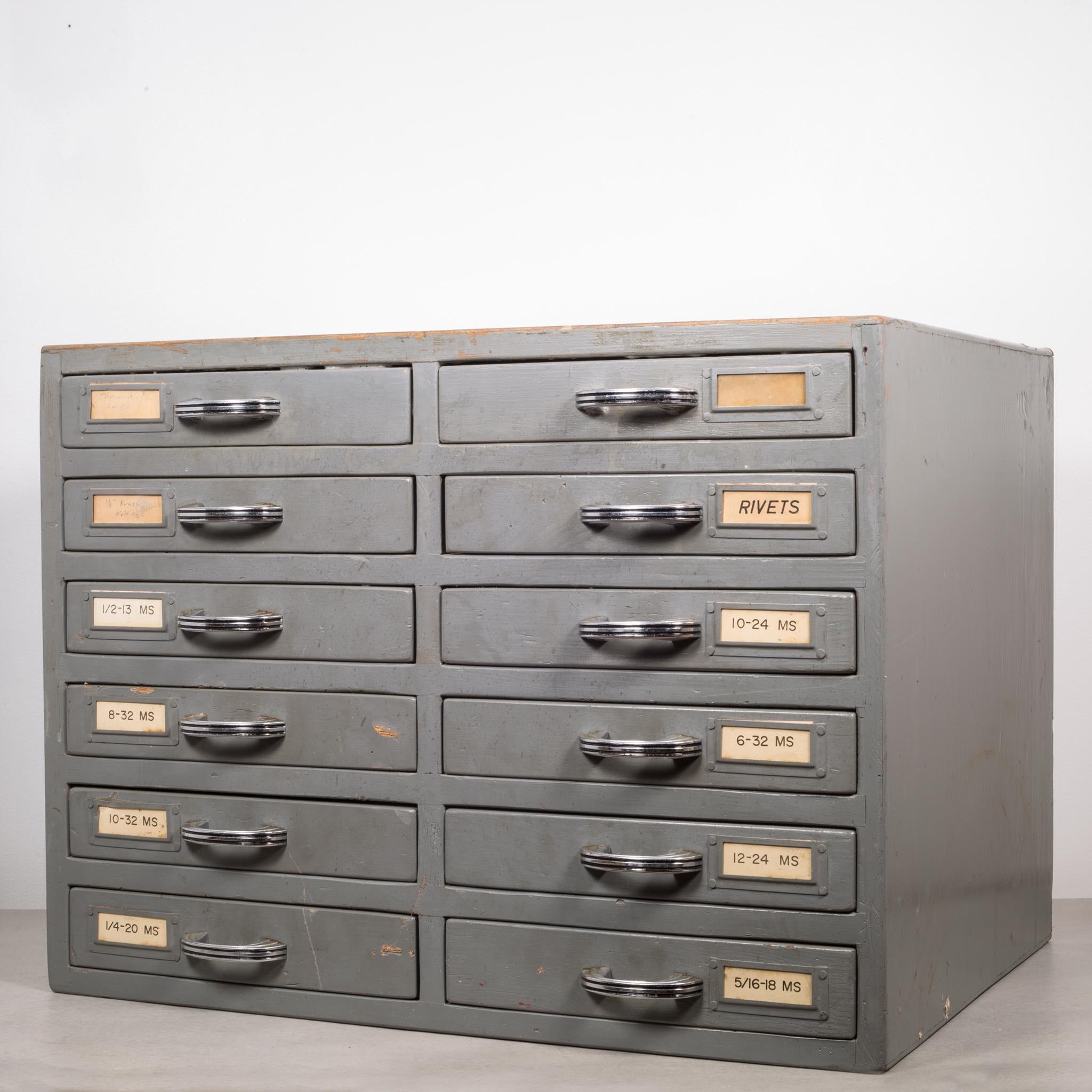 À propos de

Il s'agit d'une armoire de machiniste originale en bois avec 12 tiroirs segmentés. Les tiroirs ont des labels d'origine et des poignées Art déco en argent et noir. Les compartiments des tiroirs mesurent H 1,5 po x L 2,25 x P 3 po.