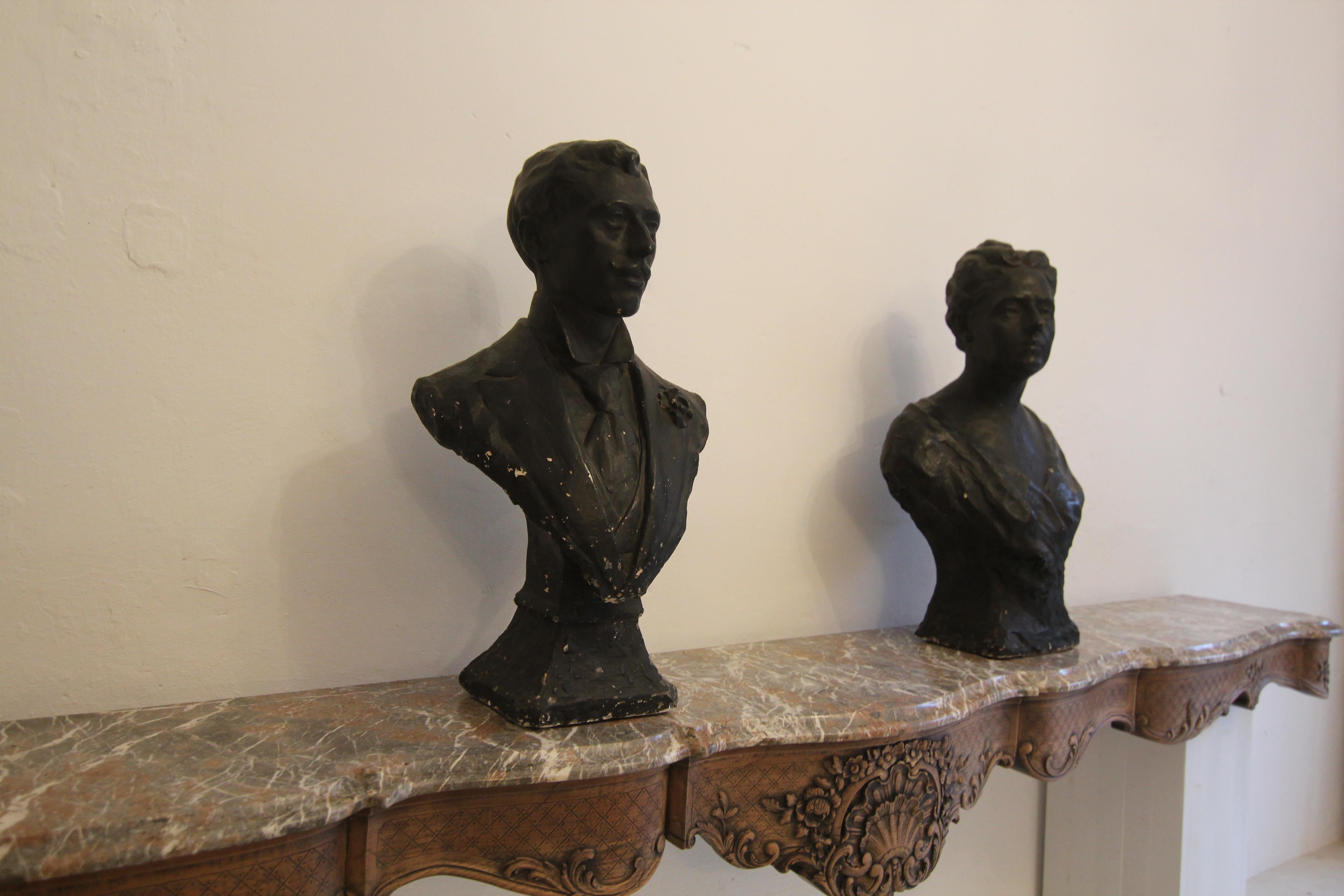 A pair of busts depicting a man and a woman. France/ Belgium, early 20th century. Made of plaster and painted in a dark colour imitating bronze.

‘Madame et Monsieur’ standing on plinths with a rectangular ground plan. The man wears a jacket with a