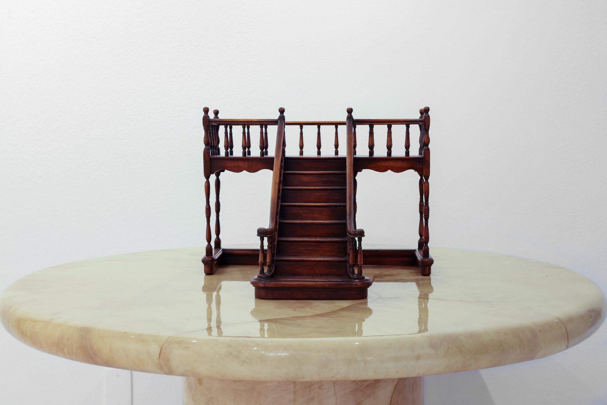 This is wonderfully carved mahogany staircase. It is an 8 step staircase with fine turned wood vertical landing and banister supports, ball barrel posts, a landing and a supportive squared off U shaped base. These architectural staircases have been