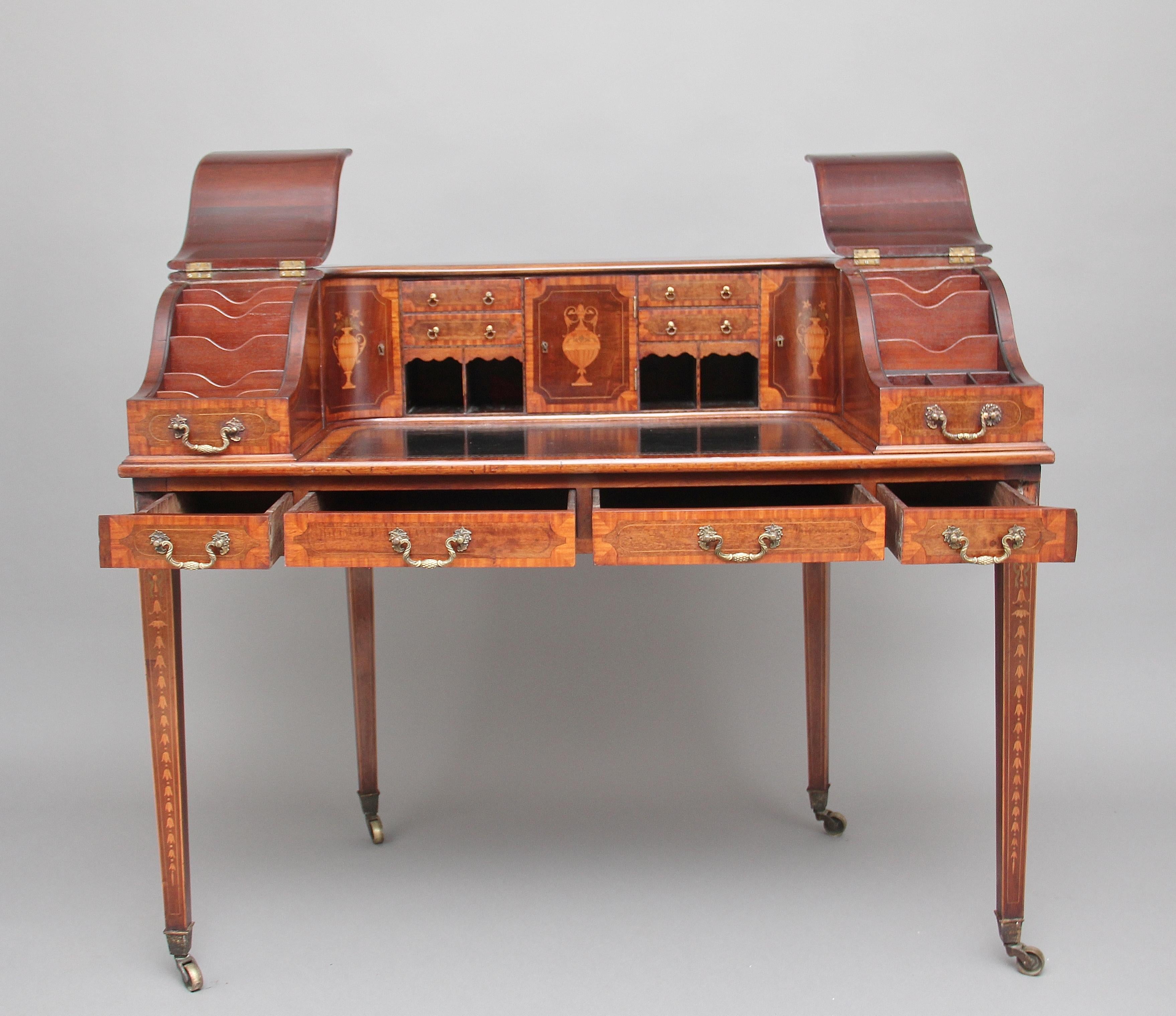 A fabulous quality early 20th century mahogany Carlton house desk on four square tapered legs ending on brass castors, the legs inlaid with boxwood lines, on the front legs there is also an inlaid garland with a string of bell flowers, above this