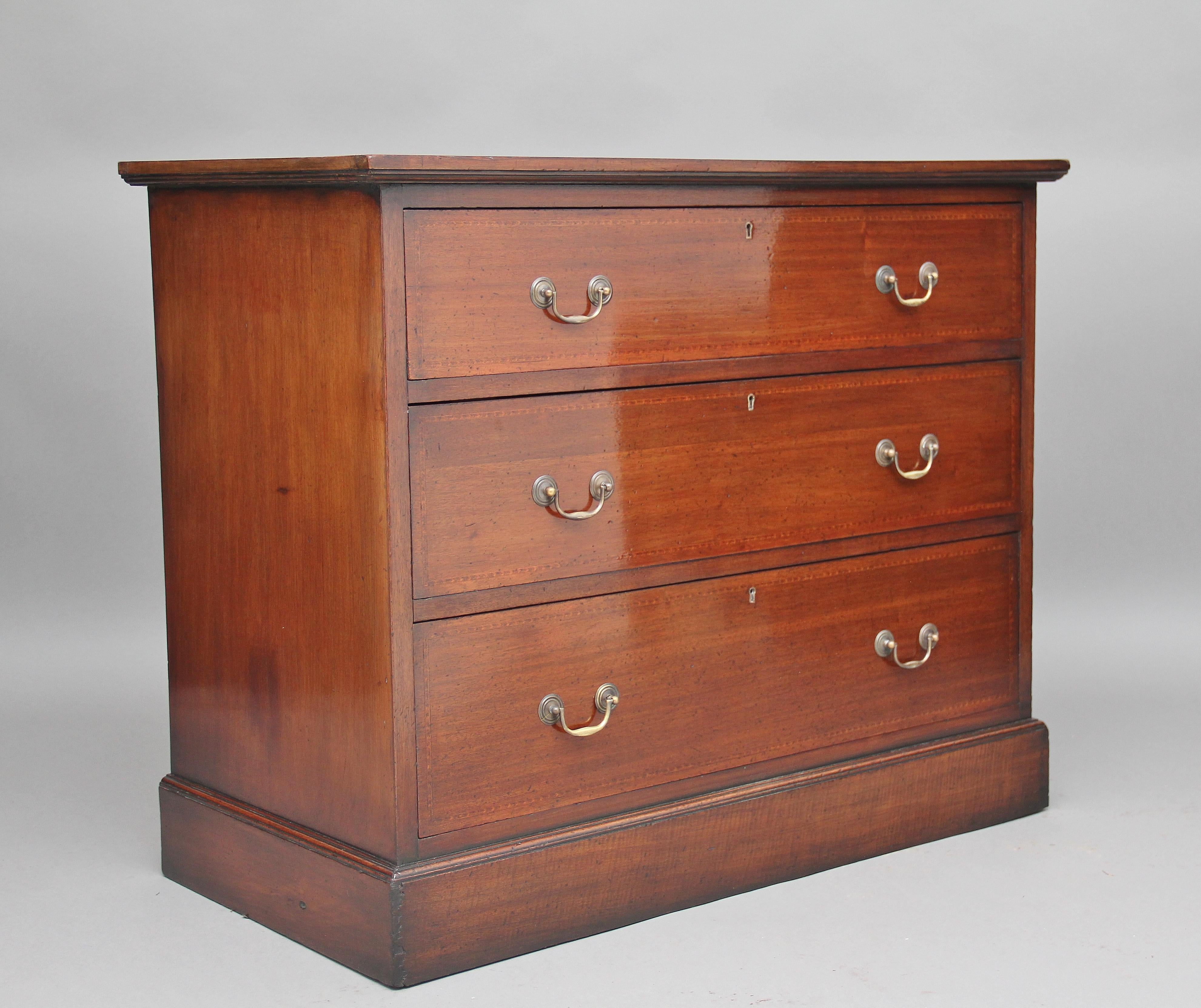 Early 20th century mahogany chest, the top decorated with boxwood and chequered line inlay, above three graduated mahogany lined drawers with brass swan neck handles, standing on a plinth base, circa 1910.
 