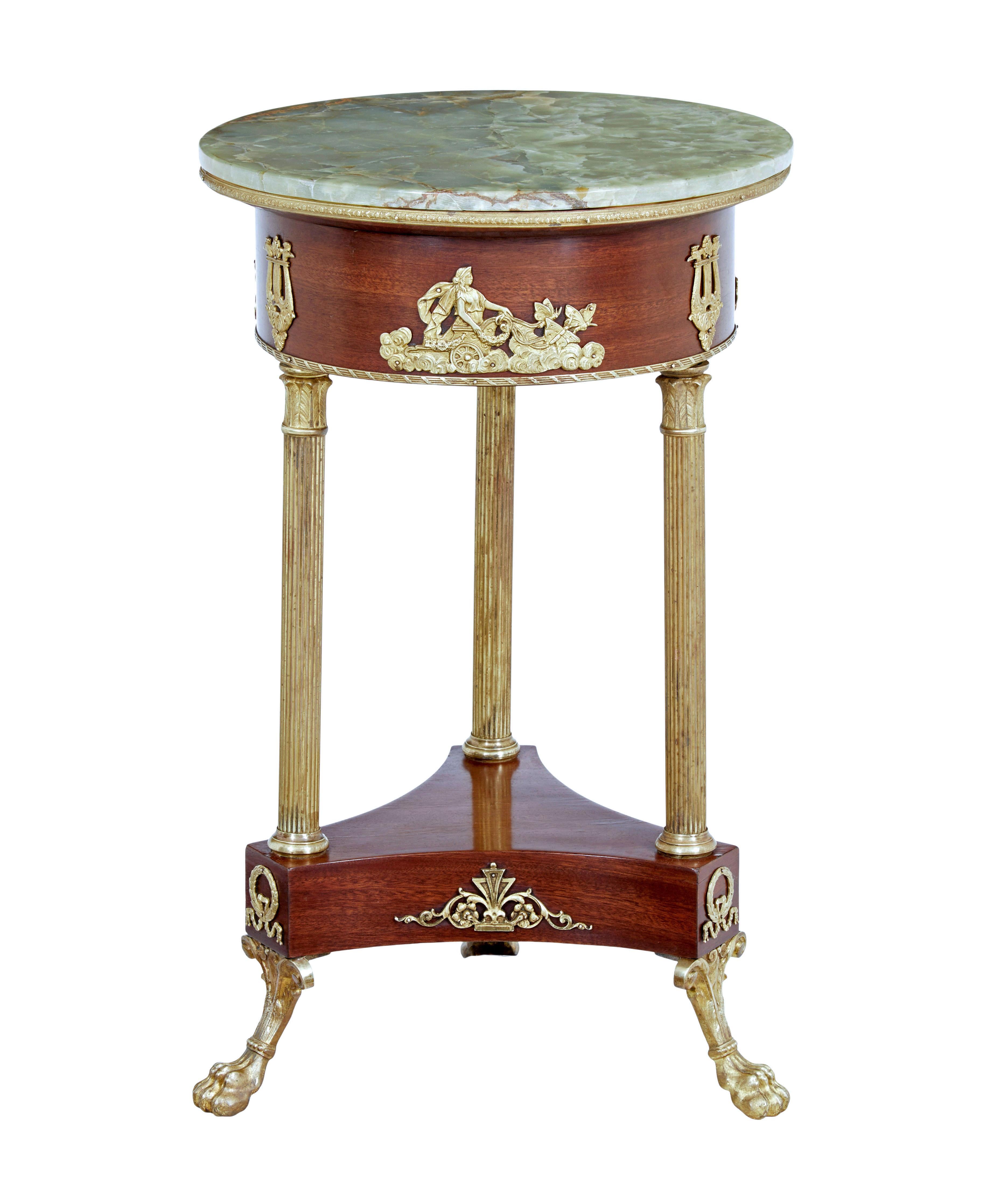 Elegant empire influenced occasional table circa 1910.

Circular green marble top standing on a mahogany support, profusely decorated with ormolu mounts and edging. Top supported by 3 column legs which link down to a shaped mahogany base with