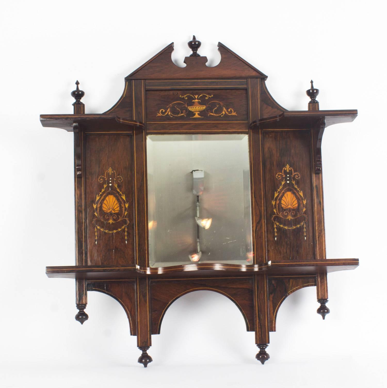 This is a beautiful antique Edwardian Goncalo Alves inlaid wall shelf with a mirrored back, circa 1900 in date.

The mirror has a beautiful frame with a broken pediment cornice to the top and fabulous marquetry decoration in the manner of Edwards