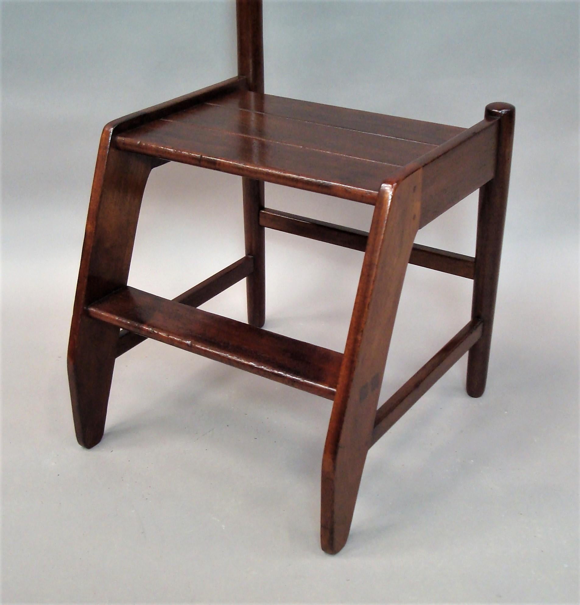 Early 20th century set of mahogany library steps of unusual form; the angled front supports housing the large platform top step with a single step below; turned tapering legs to the rear united by stretchers. The left hand side having the very