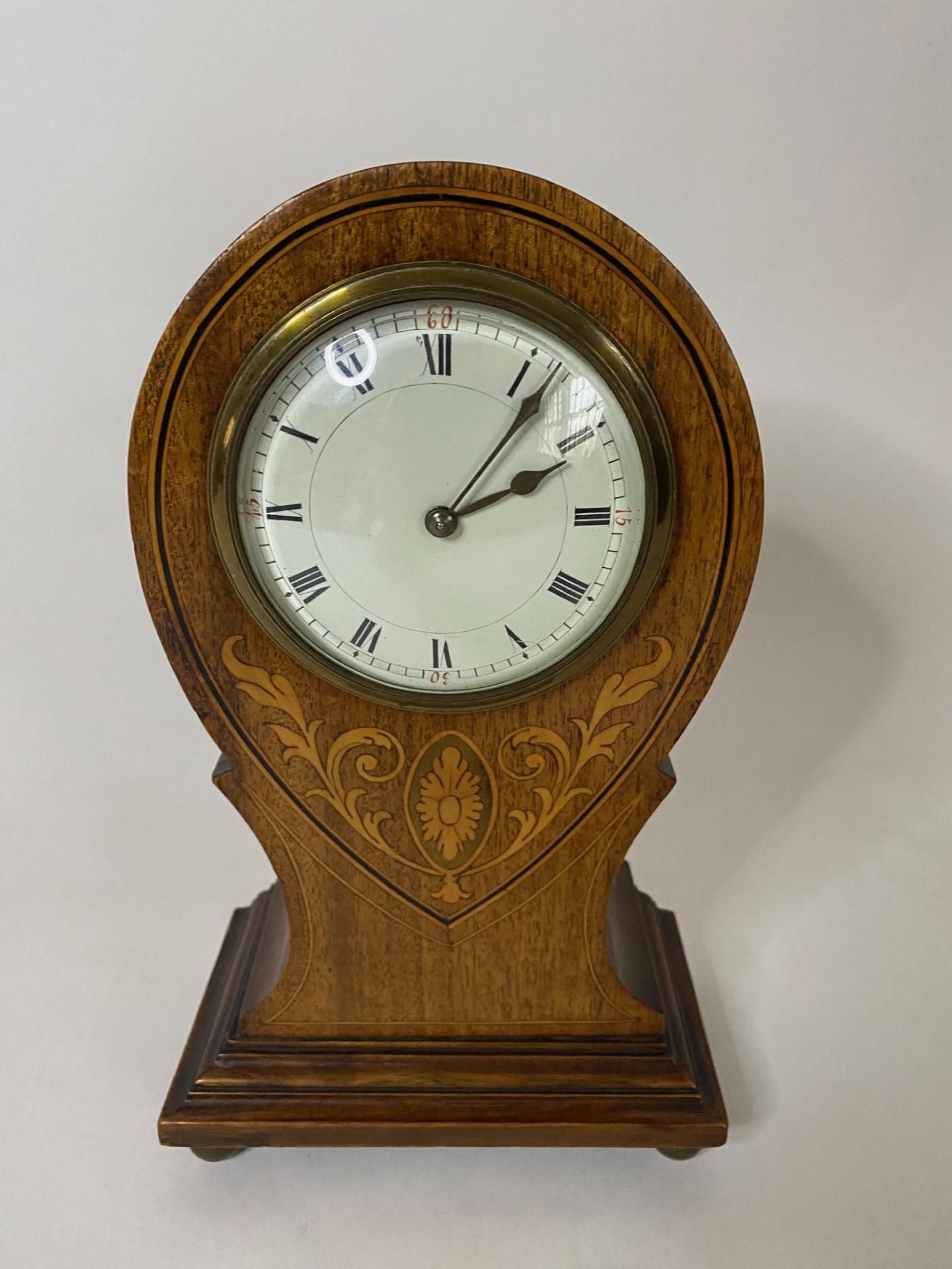 Attractive antique Edwardian inlaid mahogany balloon shaped mantle clock.  Quality mahogany case with decorative foliage inlay and a white enamel dial raised on four bun feet.  Circa 1900-1920.
