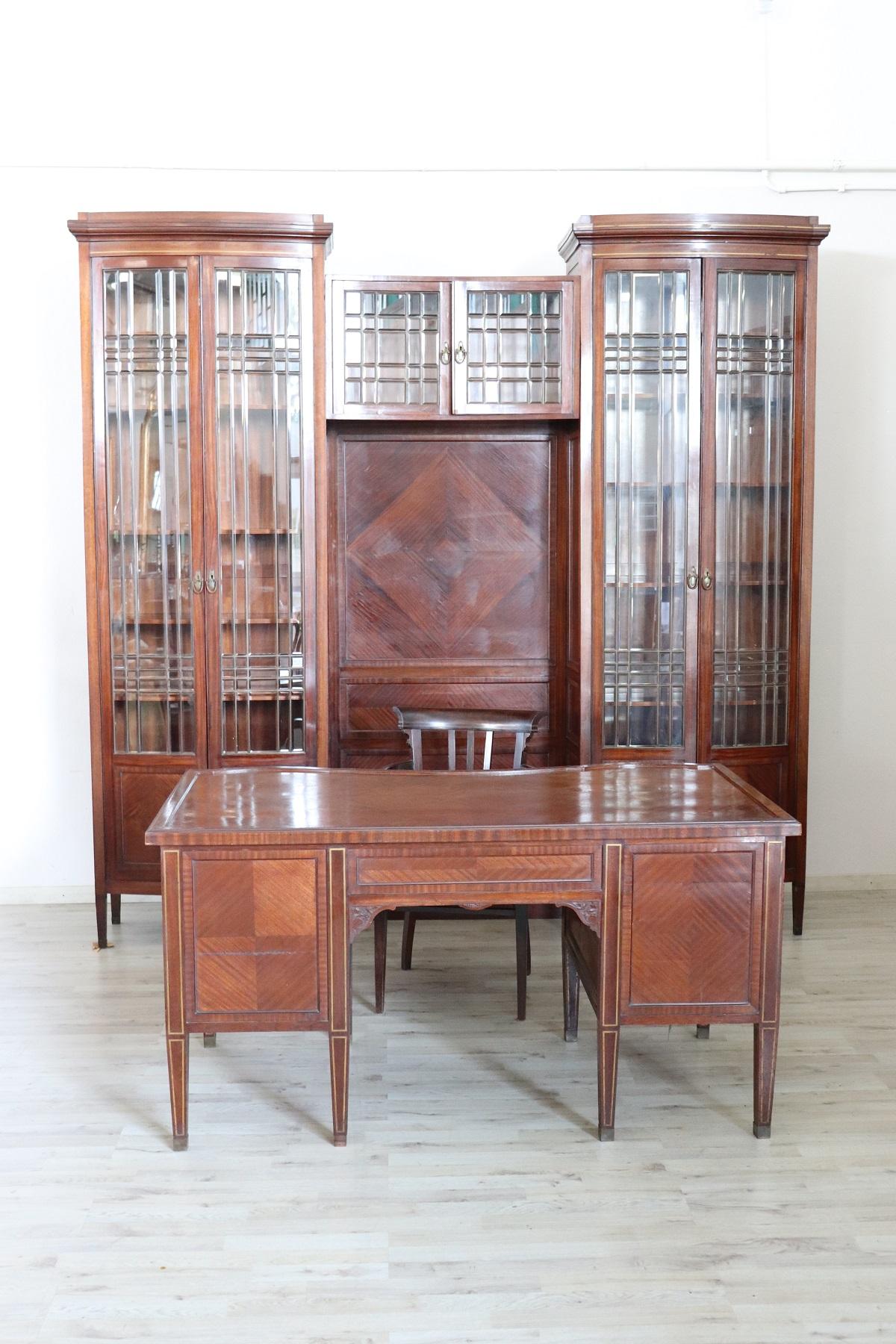 Refined and rare office furniture set, early 20th century in mahogany wood. Precious original glass. Geometric inlaid decorations in golden brass. Present brand of the Italian cabinet makers Spano and Solari who produced fine furniture in the city