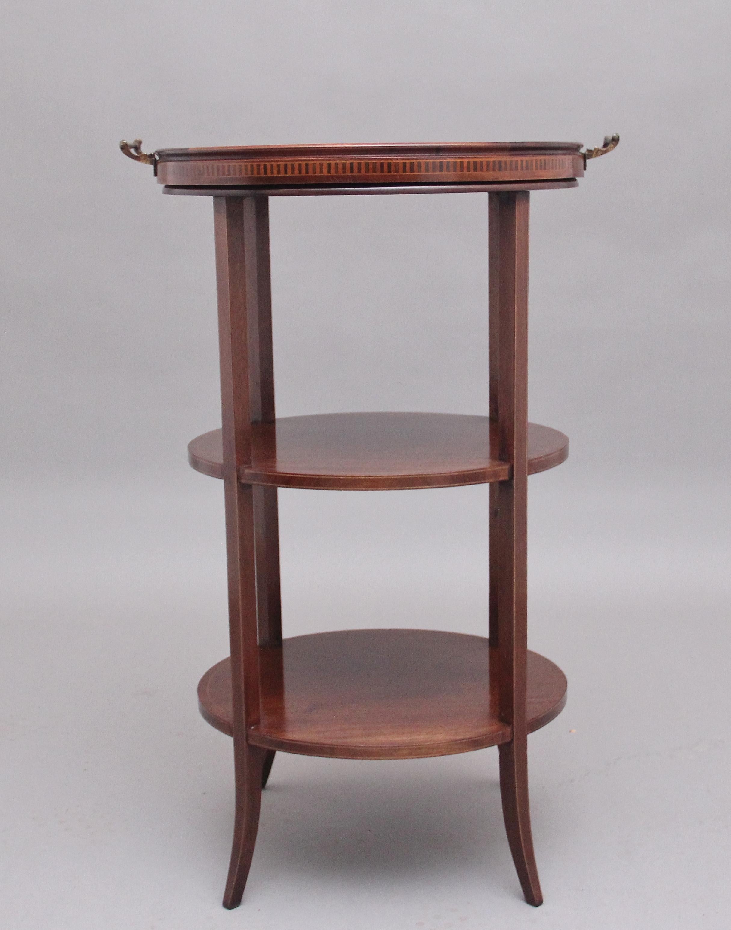 Early 20th century mahogany three tier tray top occasional table, the inlaid top tier having a removable glass tray, three circular tiers raised on square supports. Circa 1900.
 