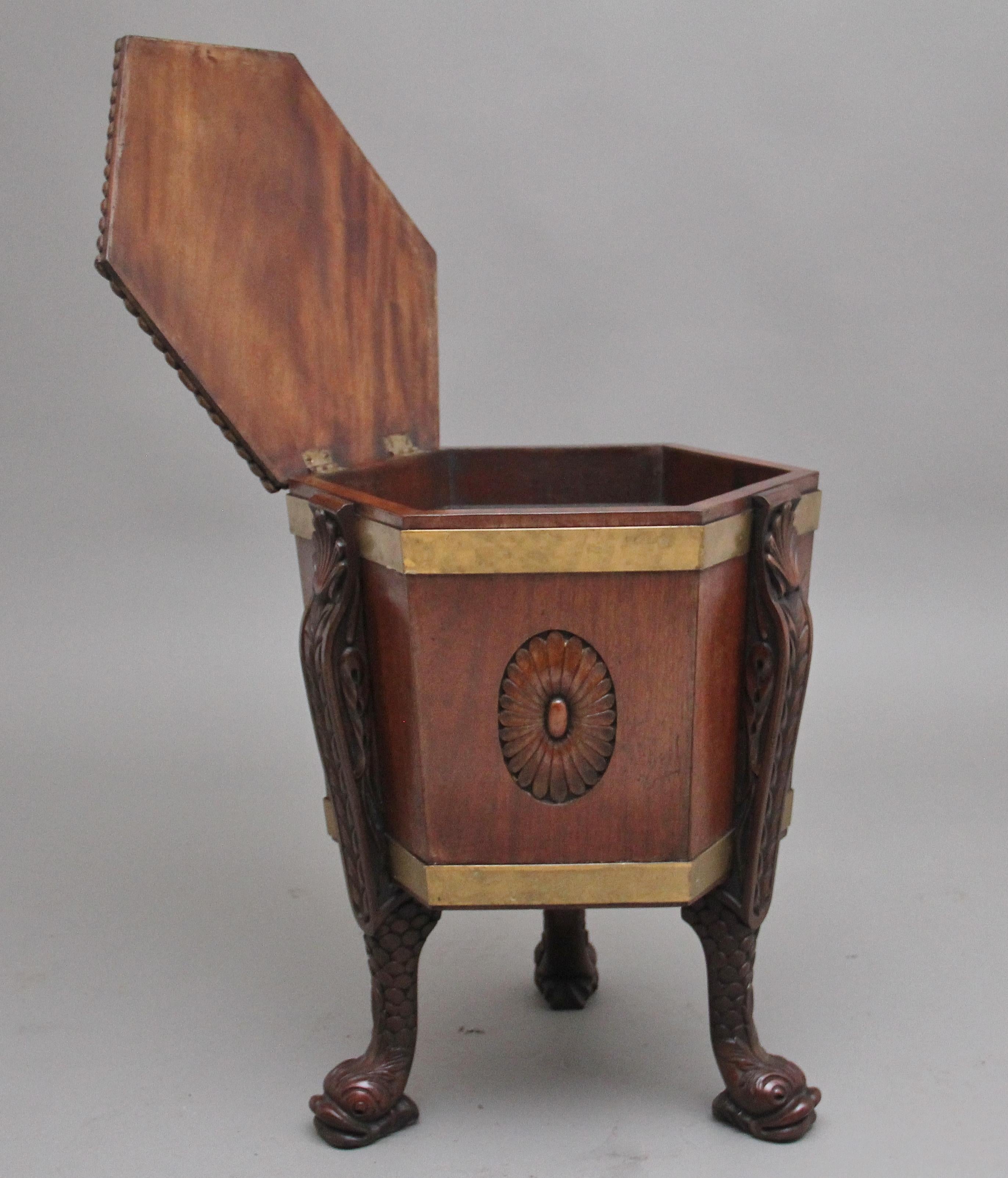 A highly decorative early 20th Century mahogany hexagon shaped wine cooler / cellarette in the Regency style, the shaped top having a gadrooned edge with a carved shell and turned and fluted finial at the centre, the hinged top opening to reveal