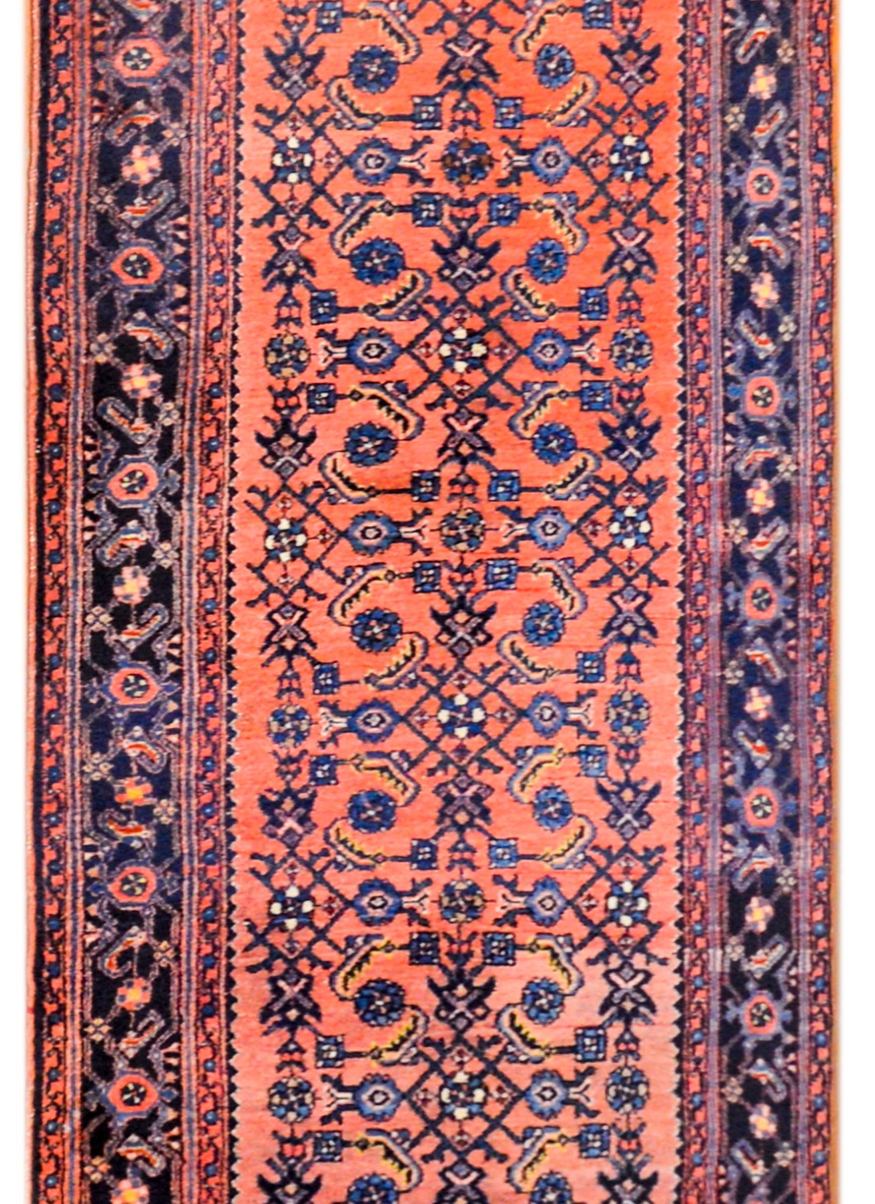 Alfombra persa Malayer Herati de principios del siglo XX, con un bello motivo de celosías florales tejidas en añil claro y oscuro, y dorado, sobre un hermoso fondo de arándano abrash. El borde es dulce, con un pequeño motivo floral y de enredaderas