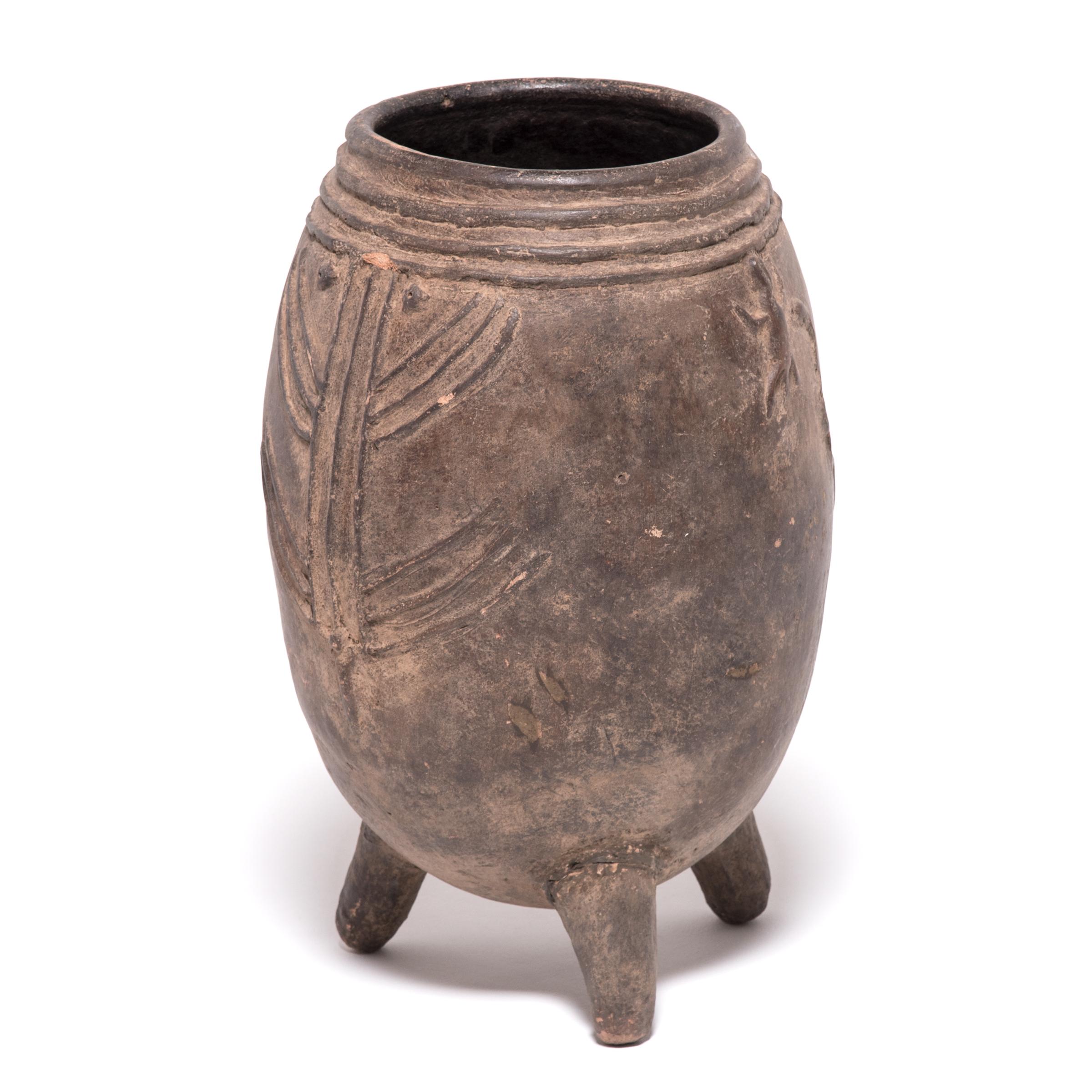 This three footed pot was used to store the millet and grains that fed the Kurumba peoples of Mali. It would have been common to keep up to a dozen unique jars in a typical home. The subtle yet fantastic surface decoration was applied before firing